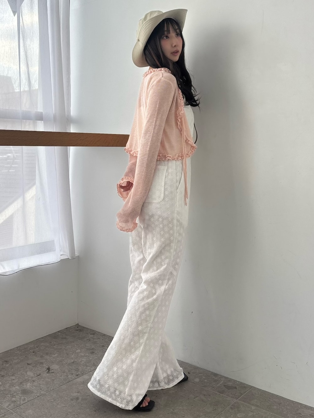 ホワイト系のつなぎ/オールインワン、ピンク系のニット/セーター、ブラウン系のサンダルを着用したレディースの春コーディネートの2枚目の写真