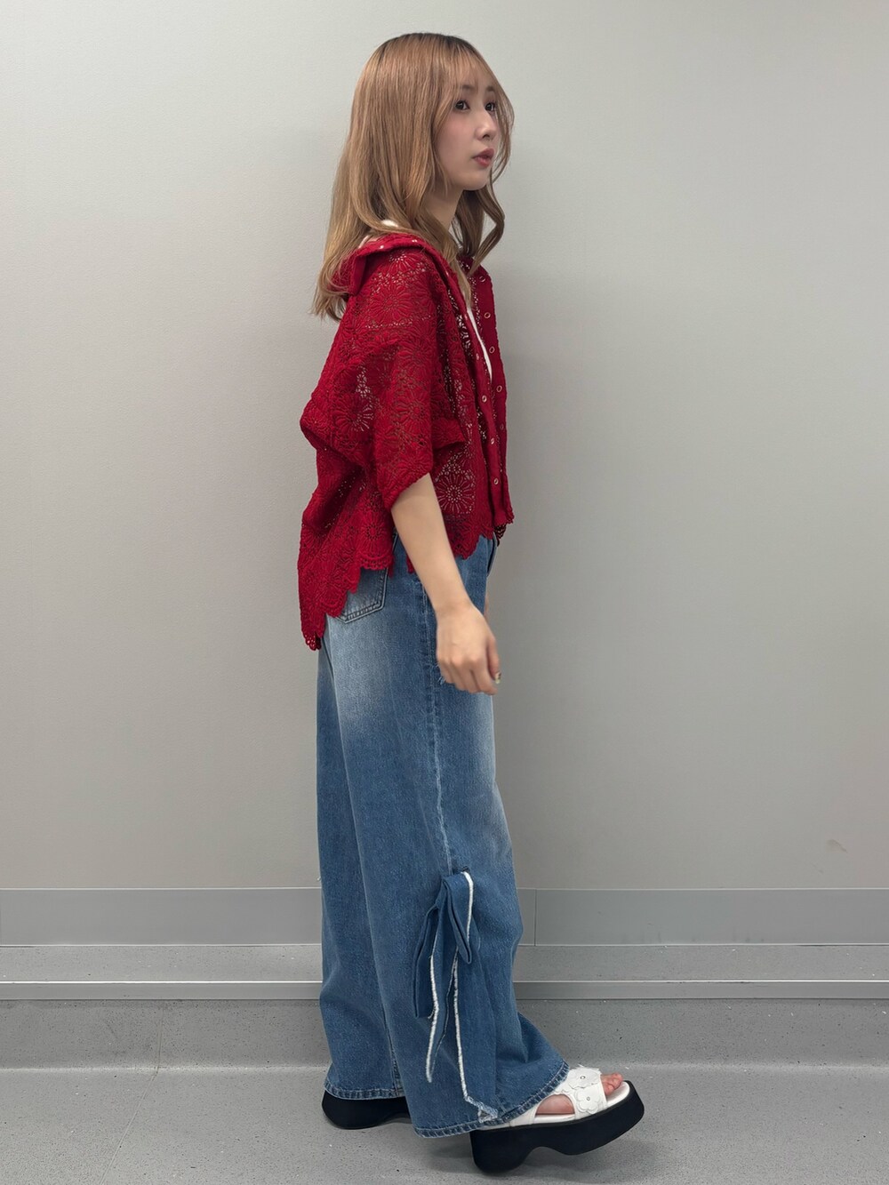 ブルー系のデニムパンツ、ホワイト系のタンクトップ、レッド系のシャツ/ブラウスを着用したレディースの春コーディネートの2枚目の写真