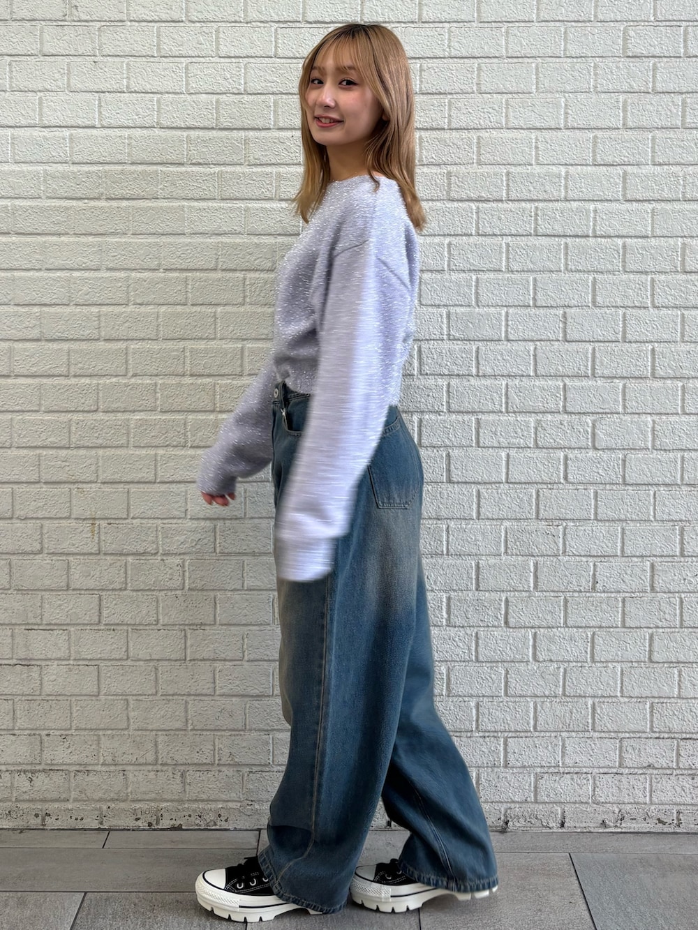 ブルー系のデニムパンツ、パープル系のニット/セーターを着用したレディースの冬コーディネートの5枚目の写真