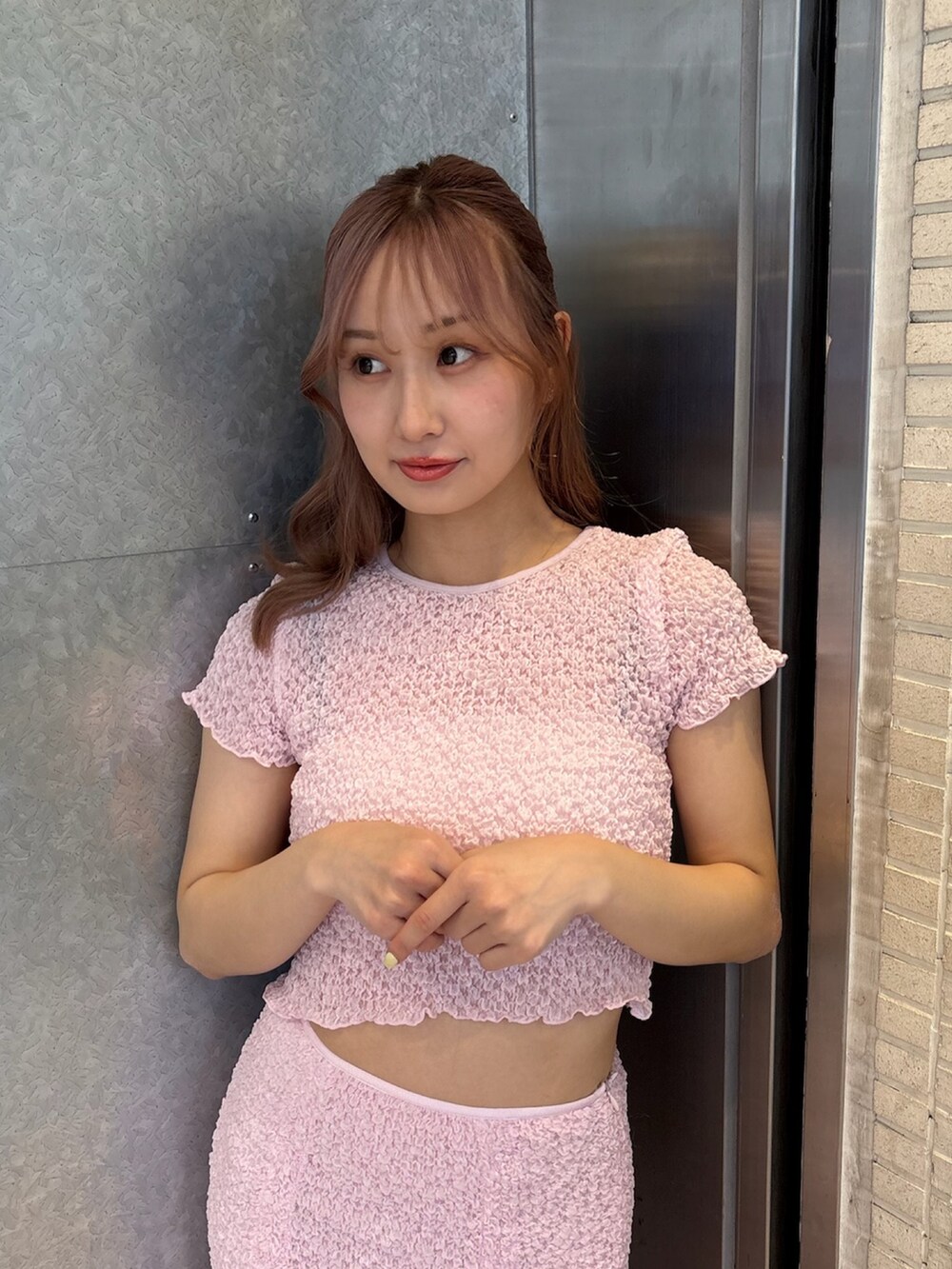 ピンク系のTシャツ/カットソー、ピンク系のスカート、ホワイト系のサンダルを着用したレディースの春コーディネートの6枚目の写真