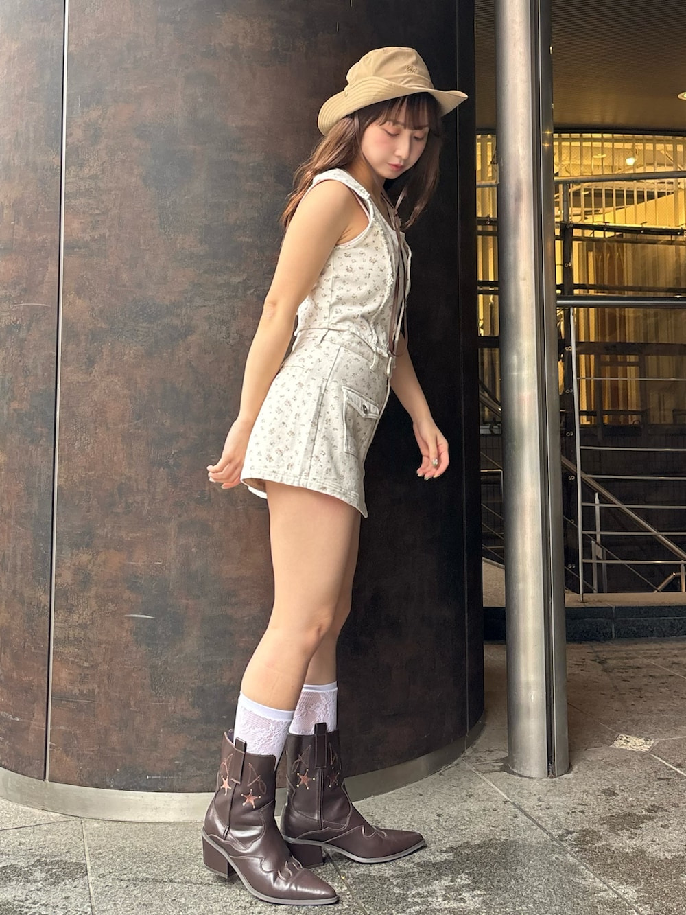 ピンク系のベスト、ピンク系のスカート、ピンク系のキャミソールを着用したレディースの春コーディネートの2枚目の写真