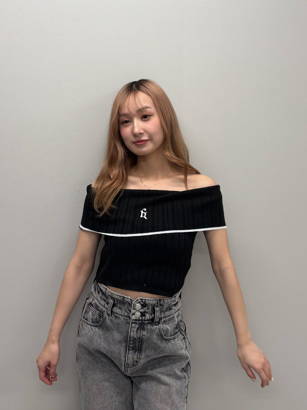 ブルー系のデニムパンツ、ブラック系のニット/セーター、ホワイト系のサンダルを着用したレディースの春コーディネートの6枚目の写真