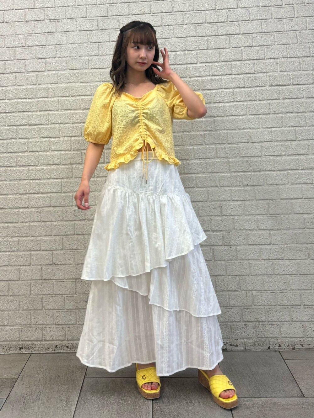 ホワイト系のスカート、イエロー系のシャツ/ブラウス、イエロー系のサンダルを着用したレディースの春コーディネートの2枚目の写真