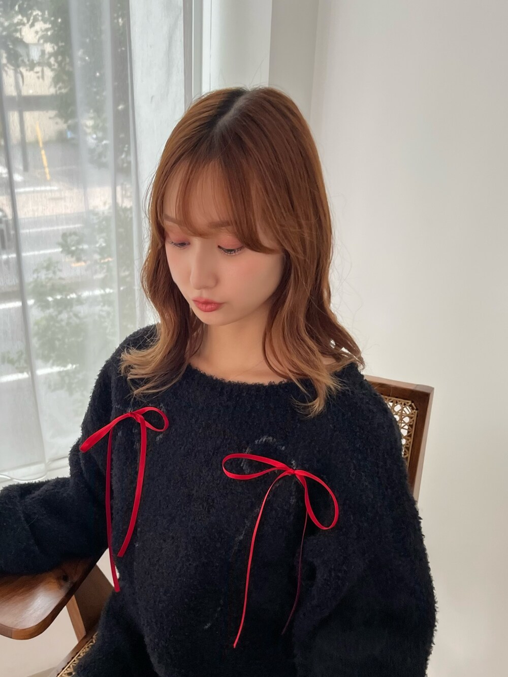 ブラック系のニット/セーター、ホワイト系のスカート、ホワイト系のブーツを着用したレディースの秋コーディネートの7枚目の写真