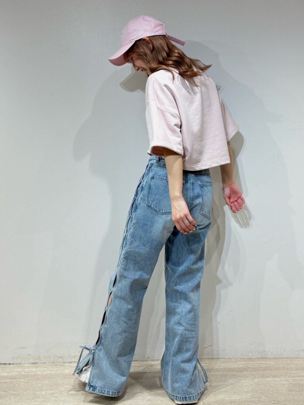ブラック系のデニムパンツ、グレー系のスウェット、ブラック系のキャップを着用したレディースの春コーディネートの4枚目の写真