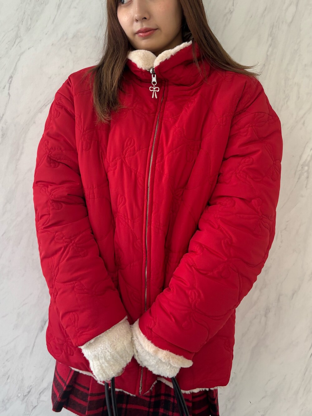 ブラック系のハンドバッグ、ブラック系のブーツ、レッド系のその他アウターを着用したレディースの夏コーディネートの6枚目の写真