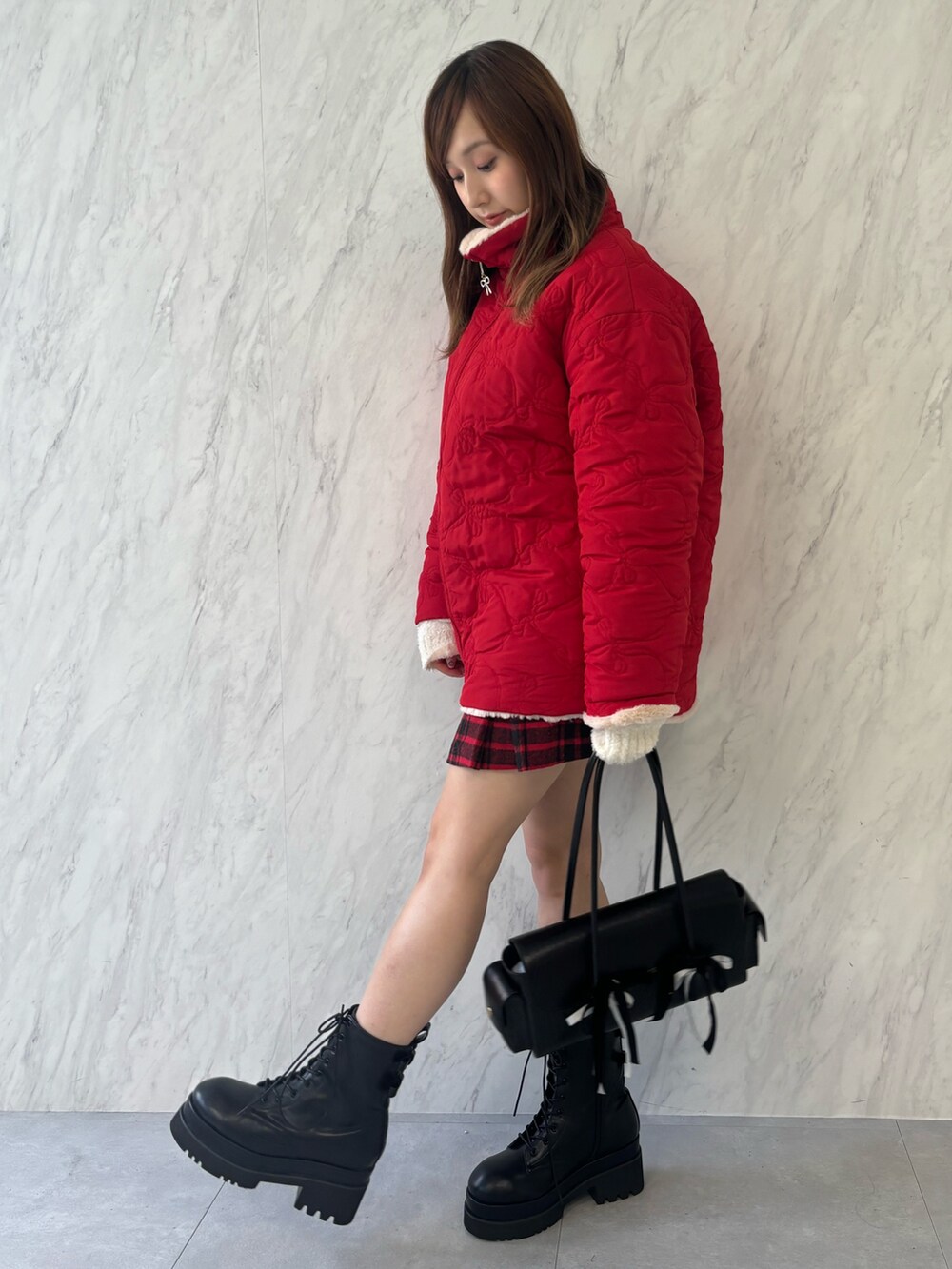 ブラック系のハンドバッグ、ブラック系のブーツ、レッド系のその他アウターを着用したレディースの夏コーディネートの3枚目の写真