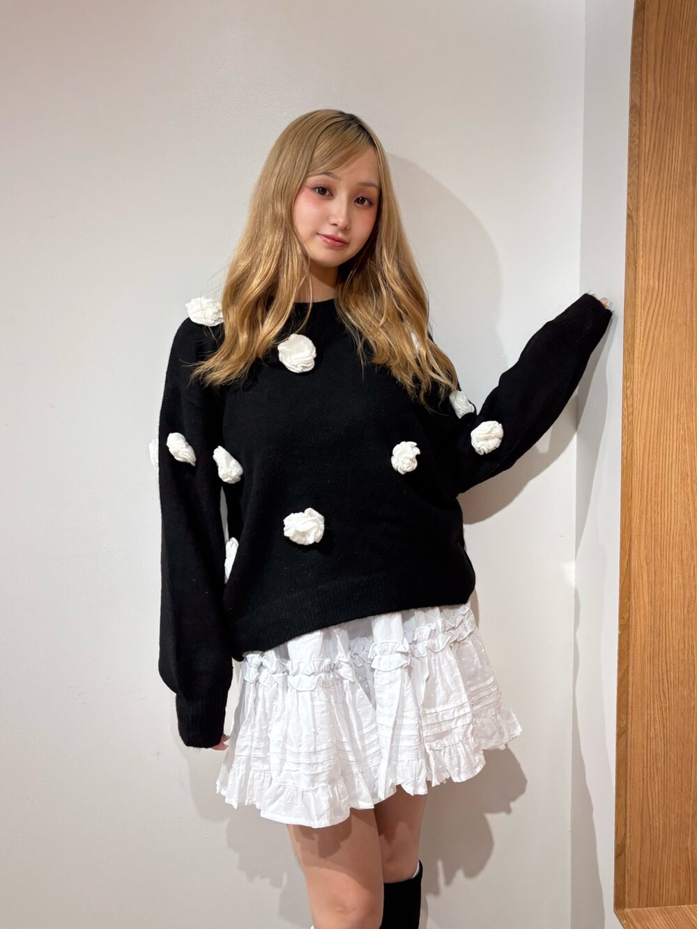 ホワイト系のスカート、ブラック系のニット/セーター、ブラック系のブーツを着用したレディースの秋コーディネートの4枚目の写真