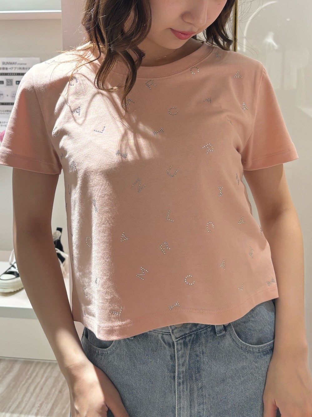 ブルー系のデニムパンツ、ピンク系のTシャツ/カットソー、イエロー系のサンダルを着用したレディースの春コーディネートの4枚目の写真