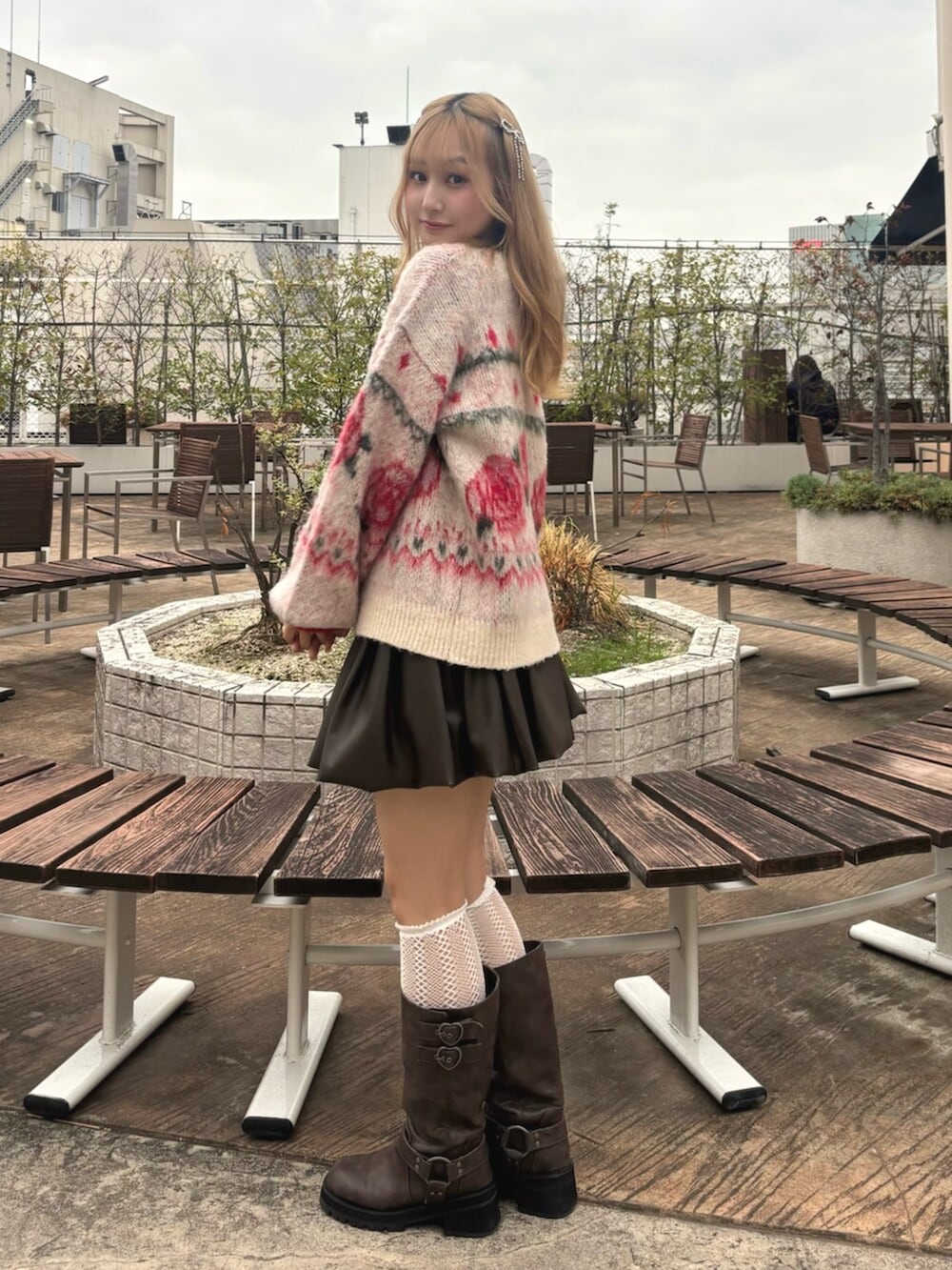 ブラウン系のブーツ、ブラウン系のスカート、ホワイト系のニット/セーターを着用したレディースの秋コーディネートの4枚目の写真