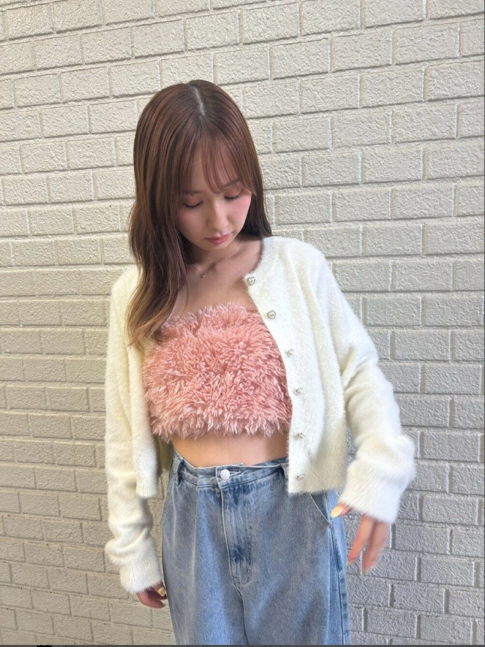 ピンク系のキャミソール、ホワイト系のカーディガン/ボレロ、ブラック系のデニムパンツを着用したレディースの秋コーディネートの6枚目の写真