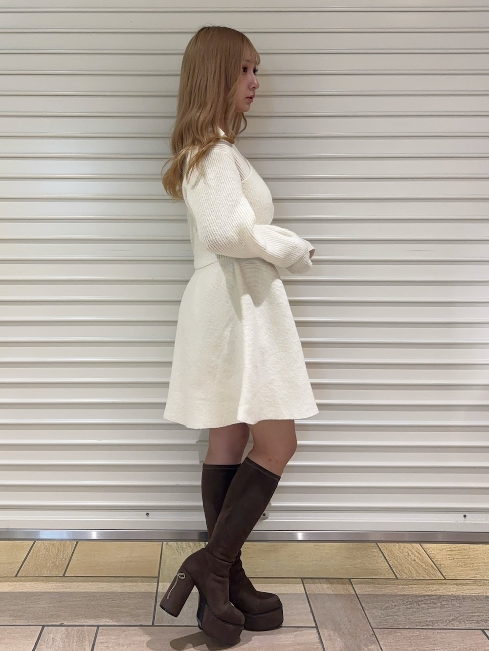 ホワイト系のワンピース、ブラウン系のブーツを着用したレディースの秋コーディネートの3枚目の写真