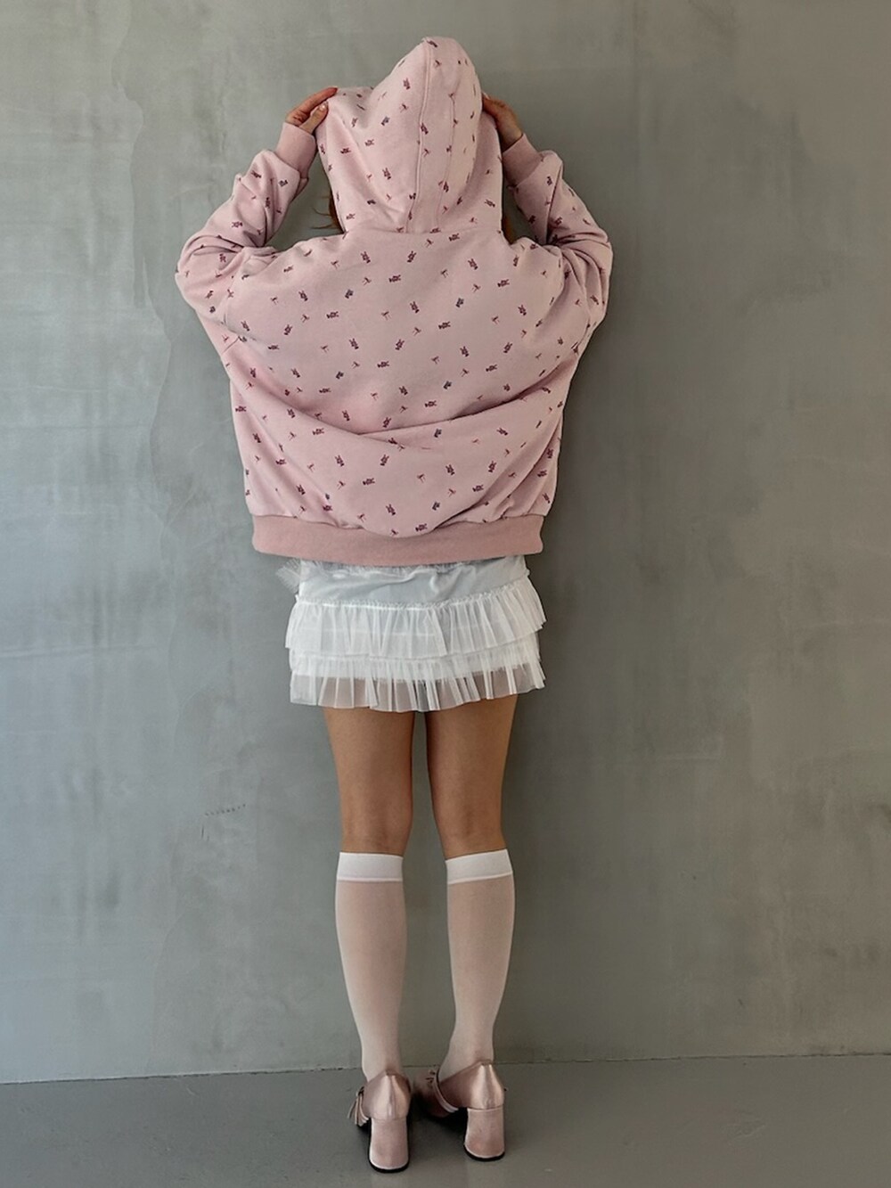 ピンク系のパーカー、ホワイト系のスカート、ピンク系のパンプスを着用したレディースの春コーディネートの5枚目の写真