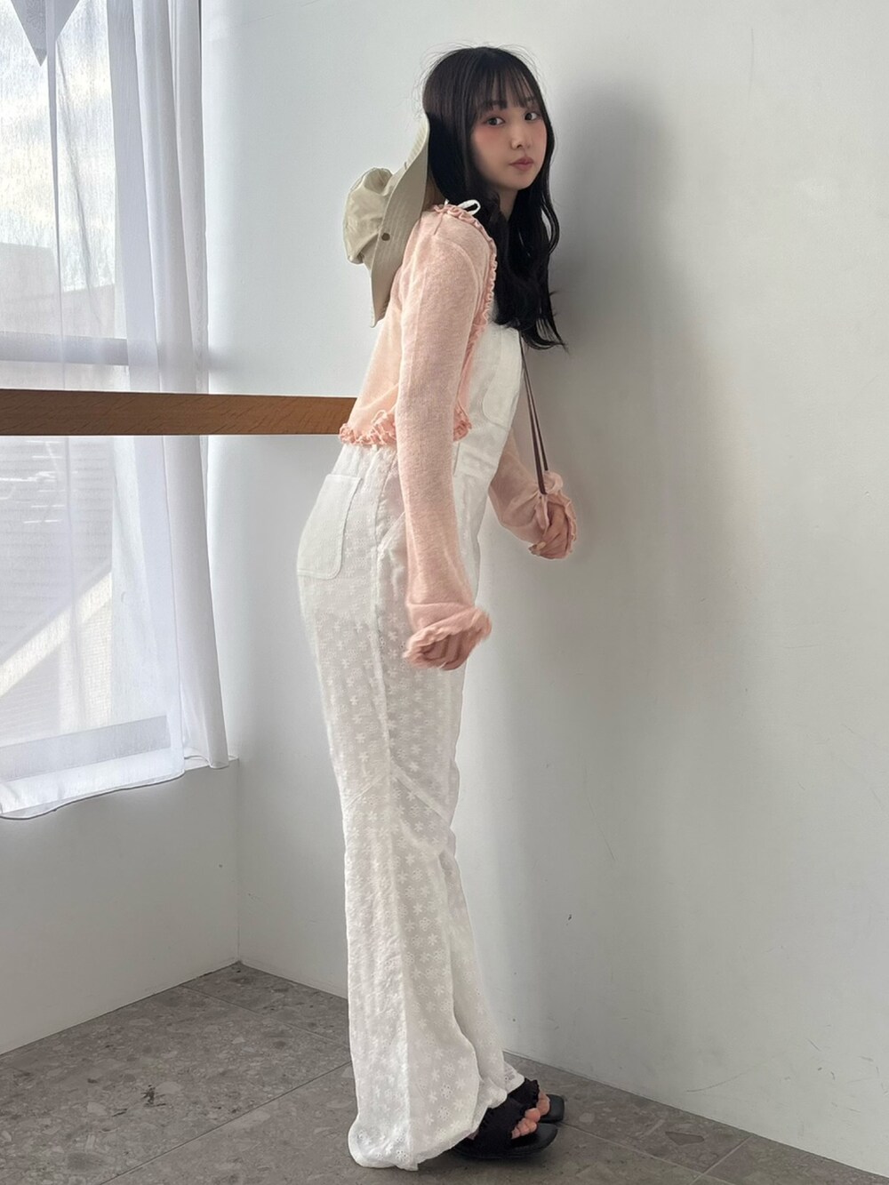 ホワイト系のつなぎ/オールインワン、ピンク系のニット/セーター、ブラウン系のサンダルを着用したレディースの春コーディネートの5枚目の写真