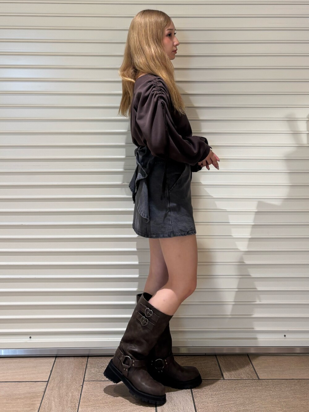 ブラック系のデニムスカート、ブラウン系のスウェット、ブラウン系のブーツを着用したレディースの秋コーディネートの4枚目の写真