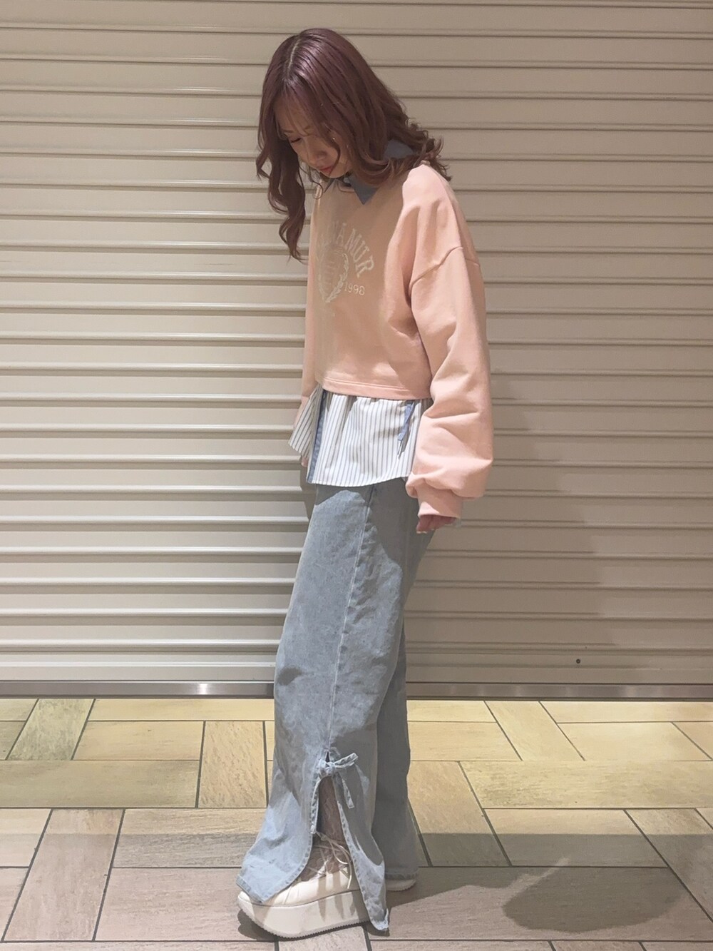 ブルー系のデニムパンツ、ブルー系のシャツ/ブラウス、ピンク系のスウェットを着用したレディースの春コーディネートの2枚目の写真