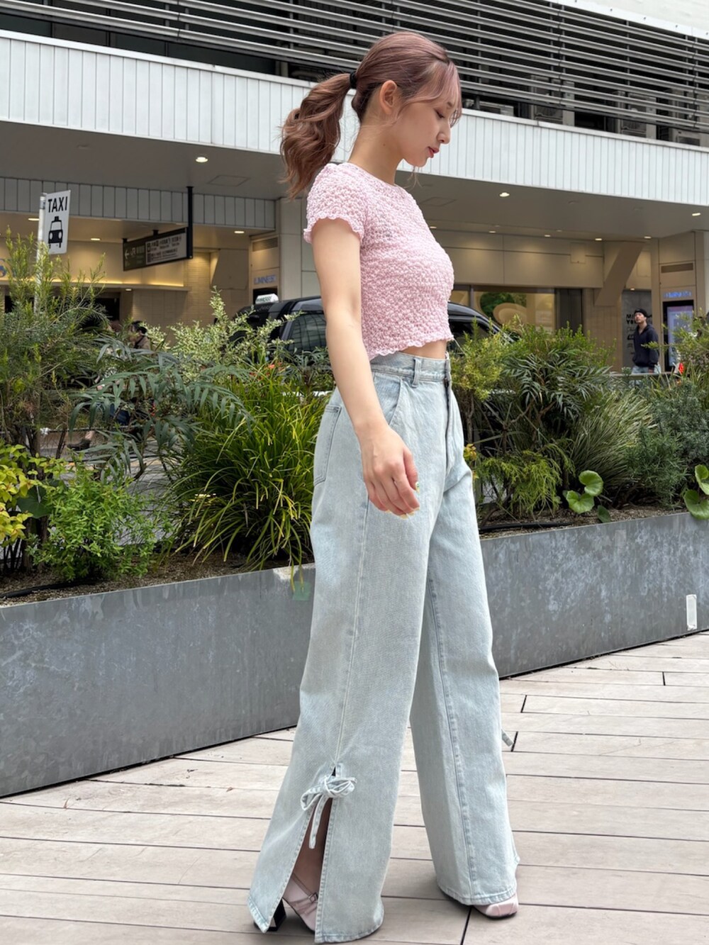 ブルー系のデニムパンツ、ピンク系のTシャツ/カットソー、ピンク系のパンプスを着用したレディースの春コーディネートの3枚目の写真