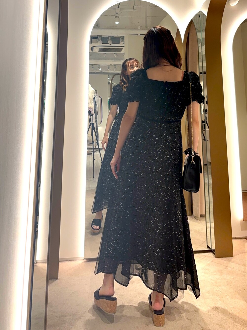 ホワイト系のハンドバッグ、ホワイト系のワンピースを着用したレディースの夏コーディネートの3枚目の写真