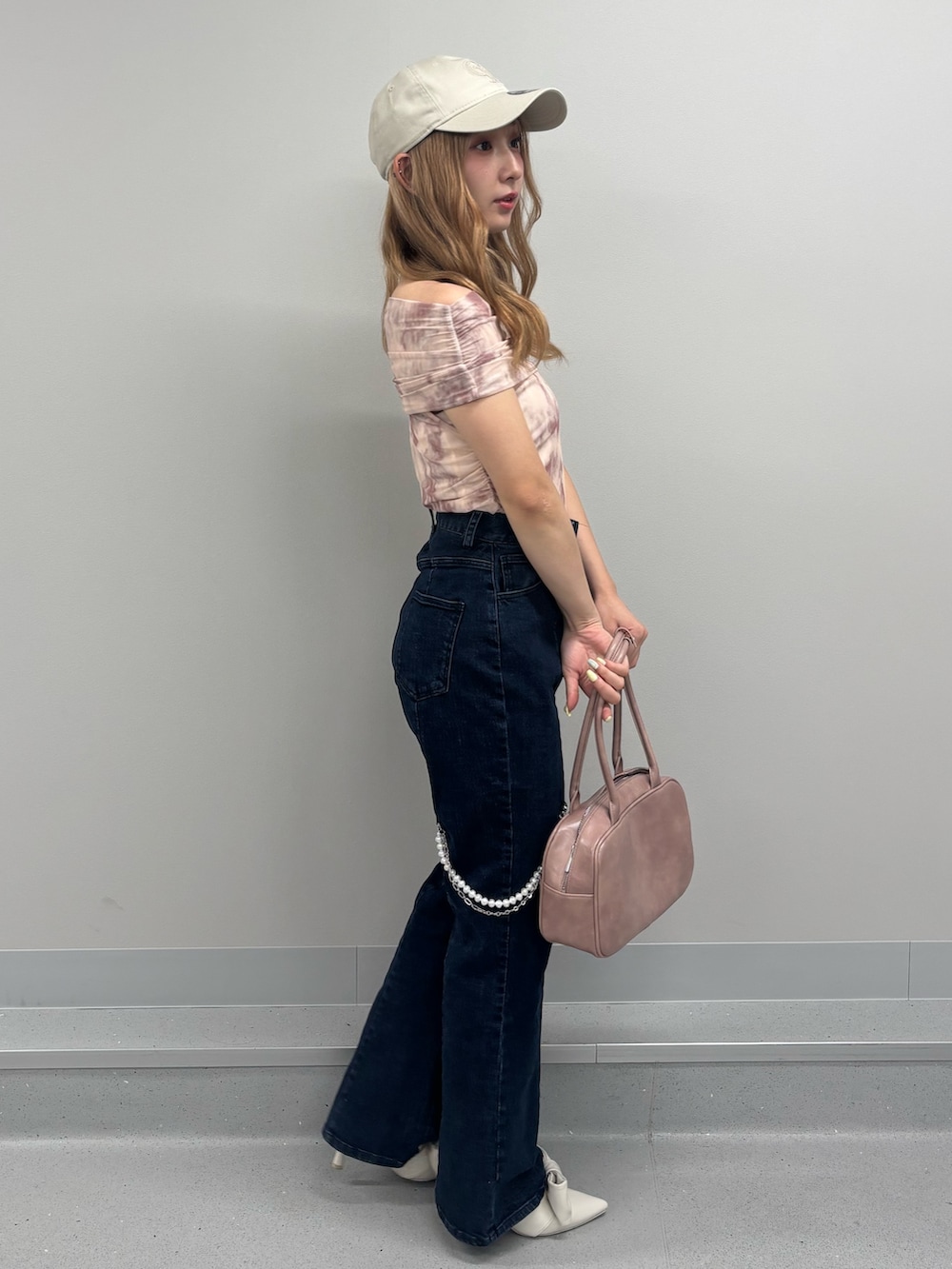 ブルー系のデニムパンツ、ピンク系のTシャツ/カットソー、ピンク系のボストンバッグを着用したレディースの夏コーディネートの2枚目の写真