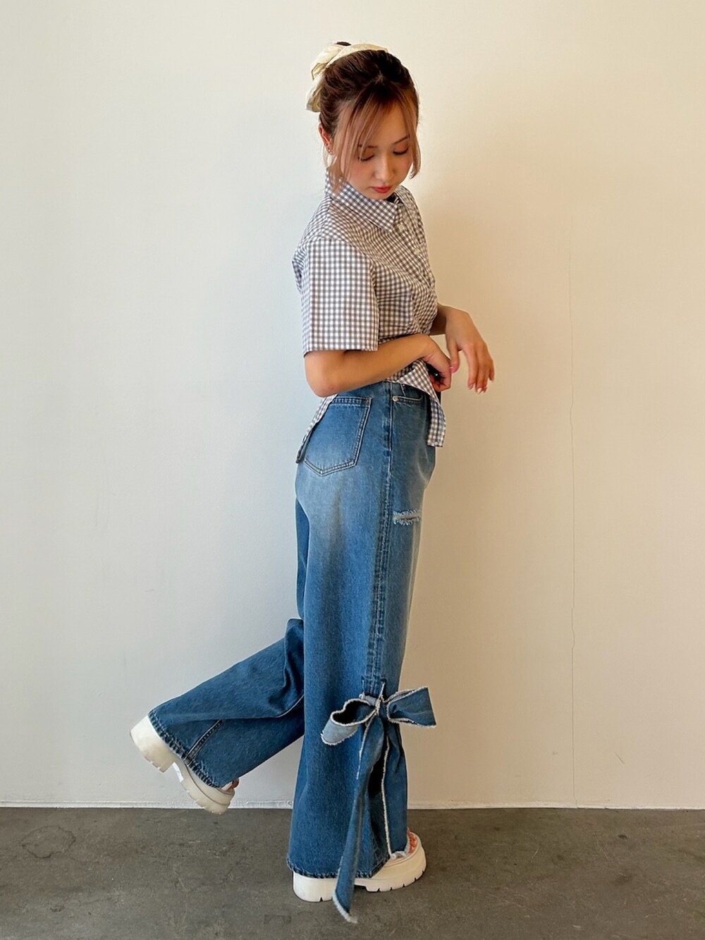 グレー系のシャツ/ブラウス、ブルー系のデニムパンツ、ホワイト系のサンダルを着用したレディースの春コーディネートの5枚目の写真