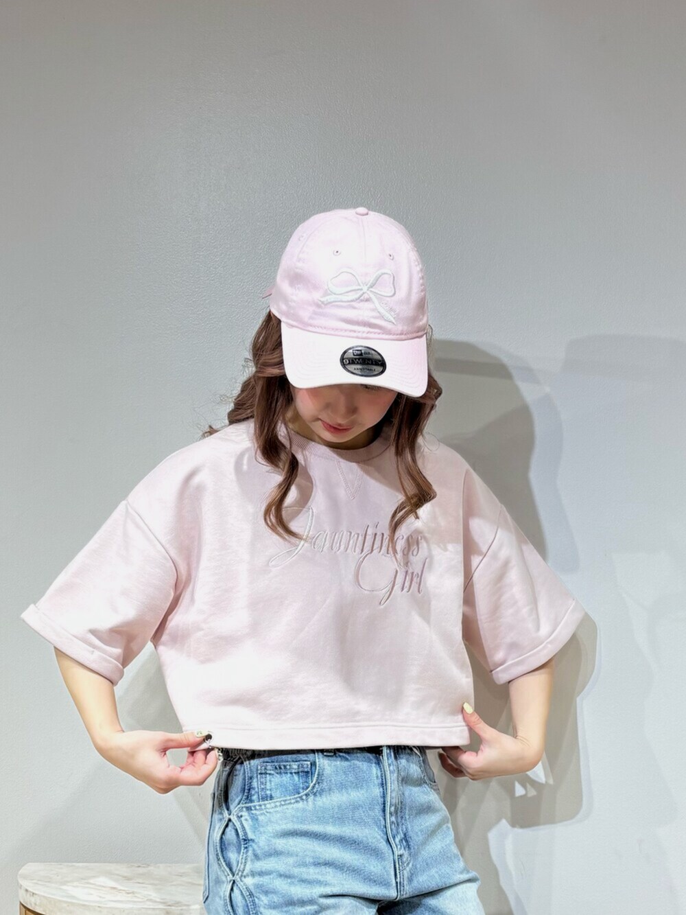 ブラック系のデニムパンツ、グレー系のスウェット、ブラック系のキャップを着用したレディースの春コーディネートの6枚目の写真
