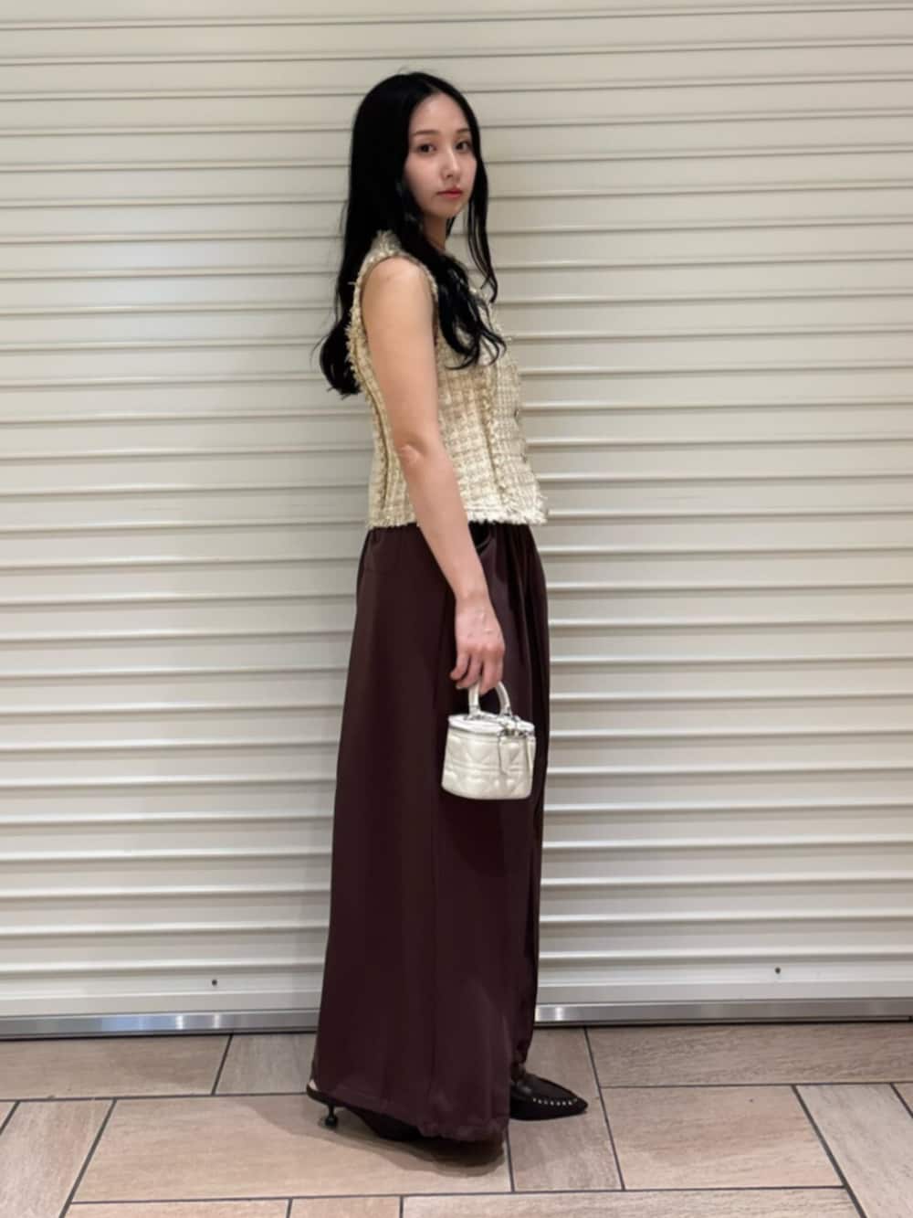 ブラウン系のサンダル、ブラウン系のスウェットパンツ、ベージュ系のベストを着用したレディースの夏コーディネートの3枚目の写真