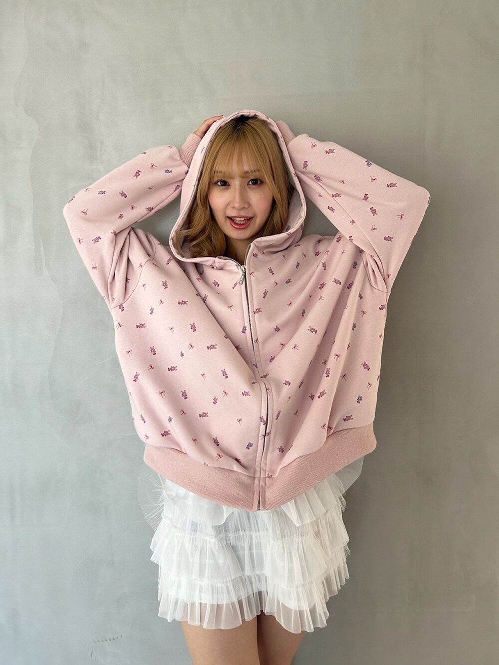 ピンク系のパーカー、ホワイト系のスカート、ピンク系のパンプスを着用したレディースの春コーディネートの9枚目の写真