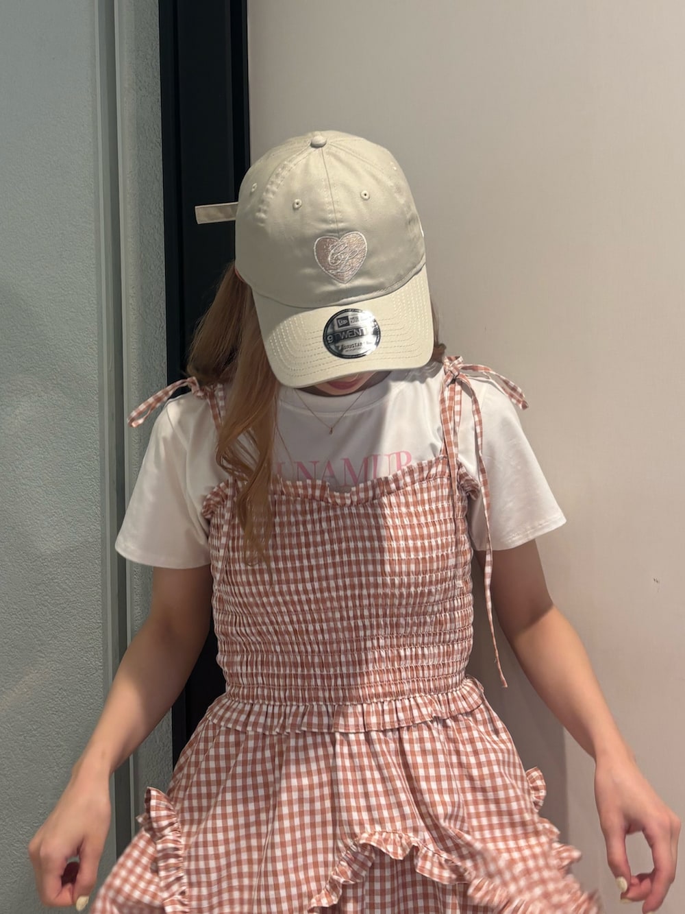 ピンク系のワンピース、ホワイト系のTシャツ/カットソー、ホワイト系のサンダルを着用したレディースの夏コーディネートの7枚目の写真