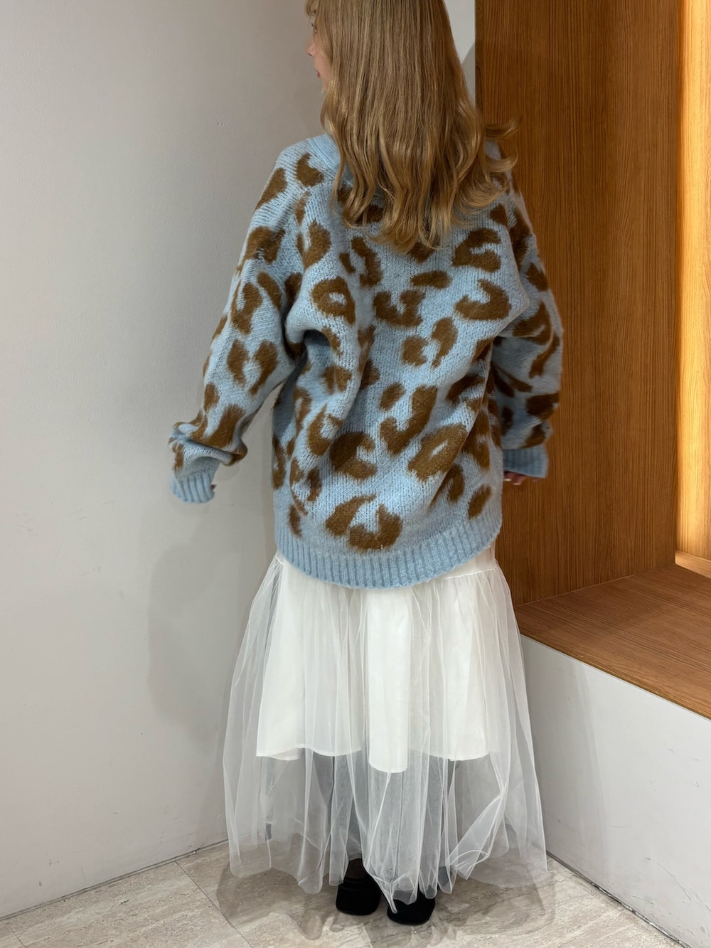 ブルー系のニット/セーター、ホワイト系のスカート、ブラウン系のブーツを着用したレディースの秋コーディネートの3枚目の写真