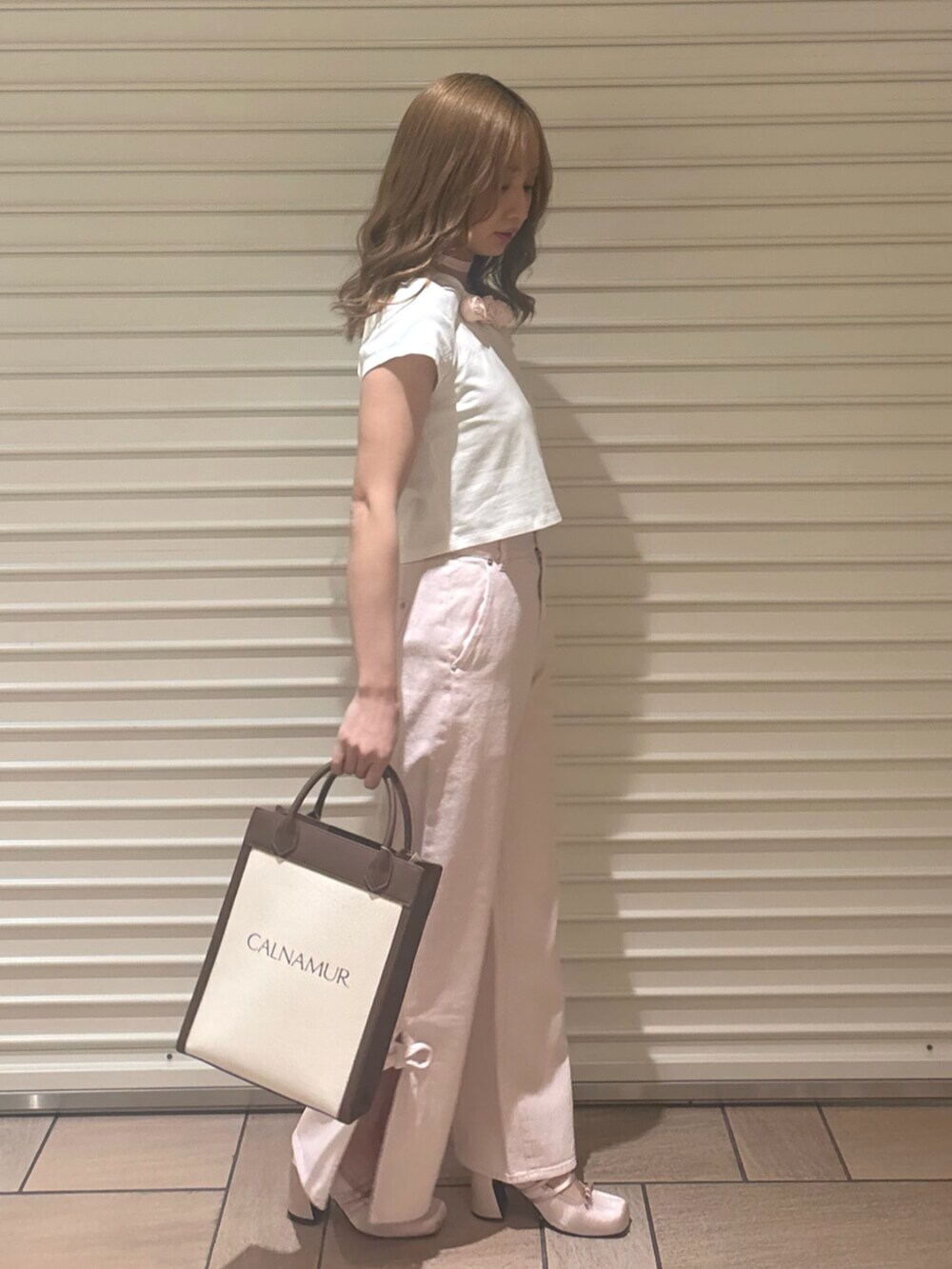 ピンク系のデニムパンツ、ピンク系のTシャツ/カットソー、ピンク系のパンプスを着用したレディースの春コーディネートの3枚目の写真