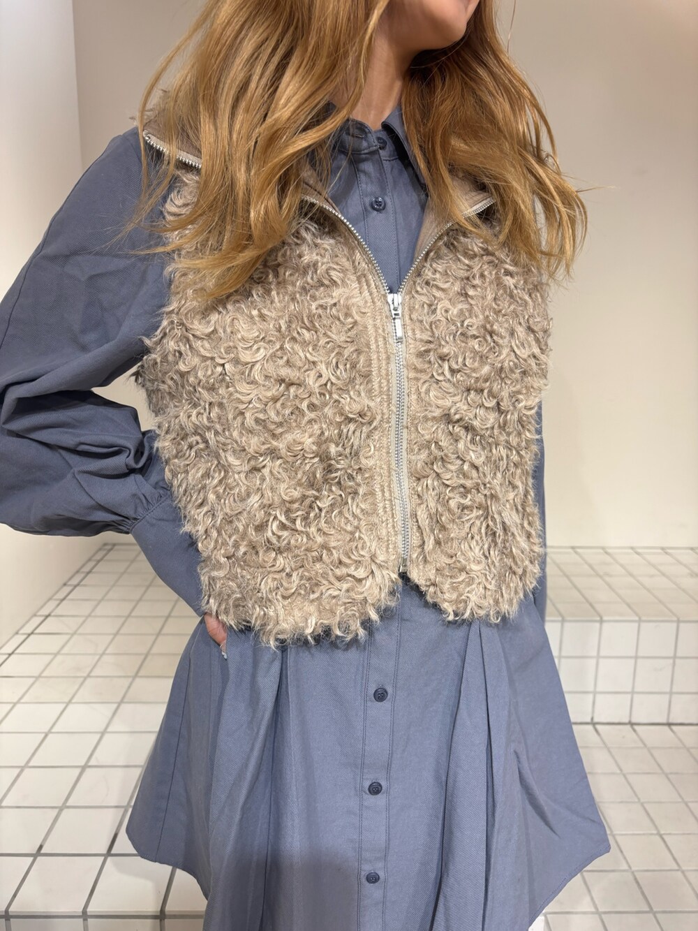 ブルー系のシャツワンピース、ベージュ系のブルゾン、ブラウン系のブーツを着用したレディースの秋コーディネートの4枚目の写真