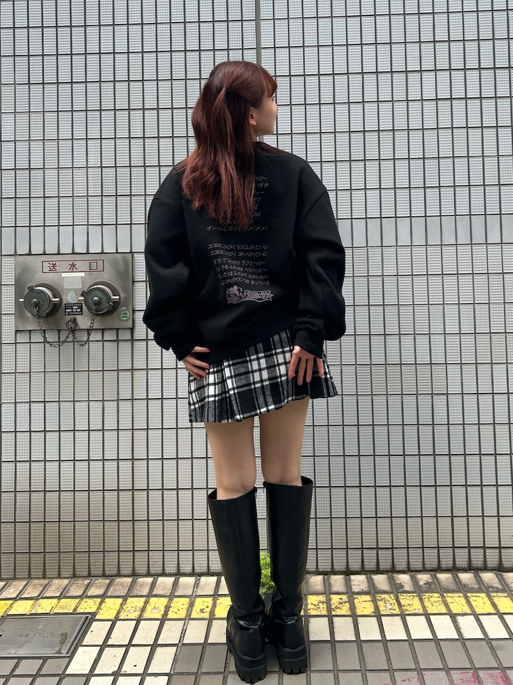 ブラック系のスウェット、レッド系のスカートを着用したレディースの秋コーディネートの3枚目の写真