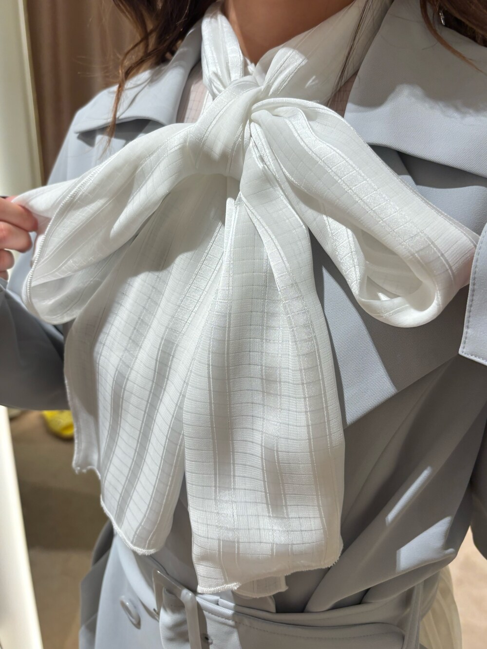 ブルー系のトレンチコート、ホワイト系のシャツ/ブラウスを着用したレディースの春コーディネートの7枚目の写真