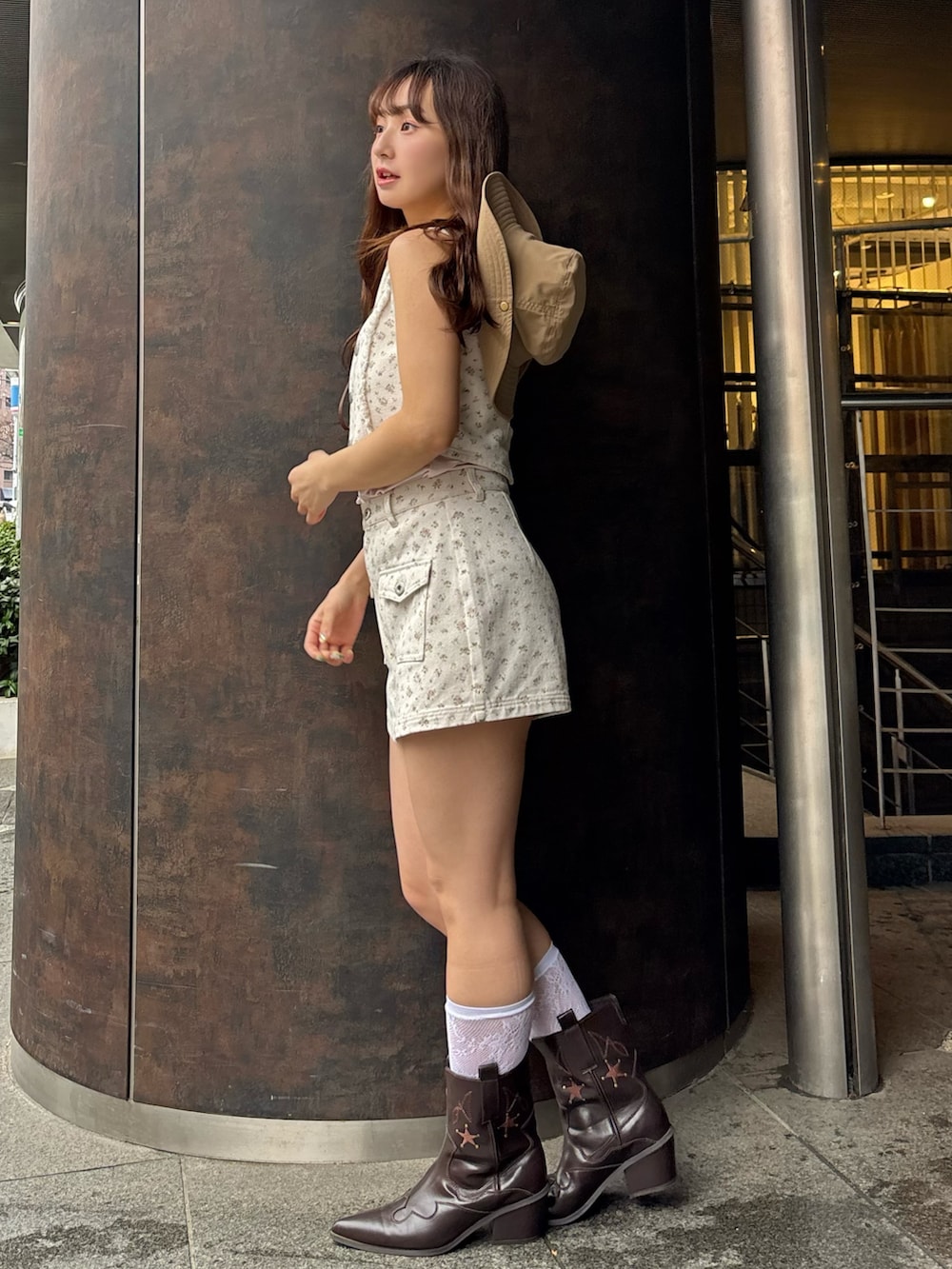 ピンク系のベスト、ピンク系のスカート、ピンク系のキャミソールを着用したレディースの春コーディネートの4枚目の写真