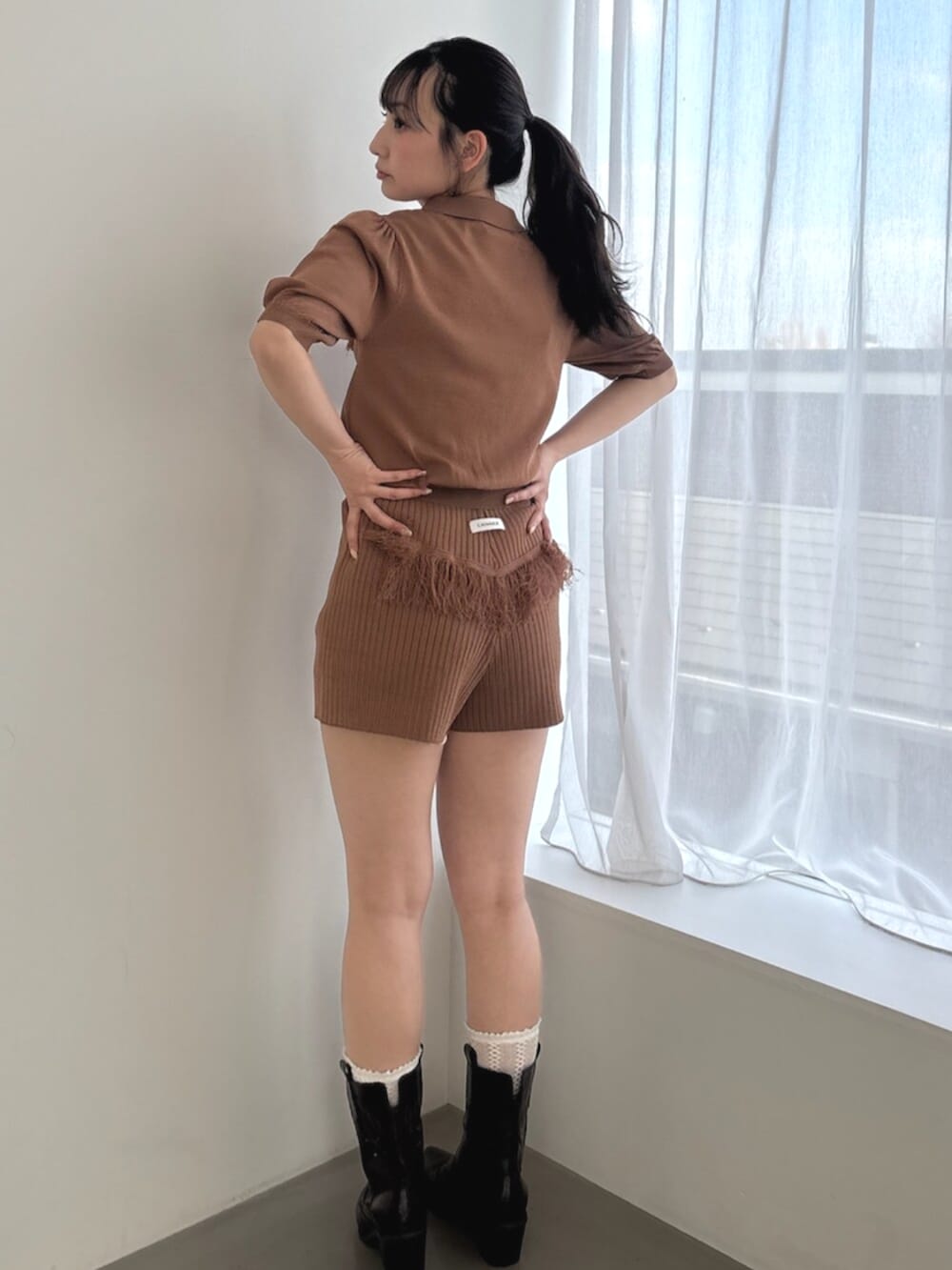 ブラウン系のその他パンツ、ブラウン系のニット/セーター、ブラック系のブーツを着用したレディースの春コーディネートの3枚目の写真