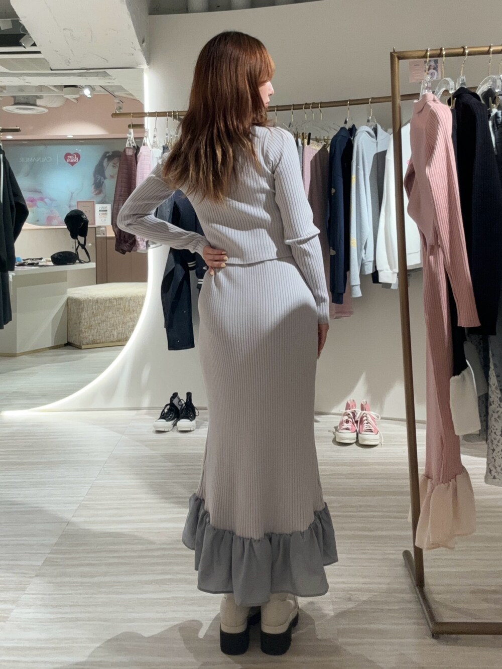 グレー系のワンピース、ブラック系のブーツを着用したレディースの秋コーディネートの3枚目の写真