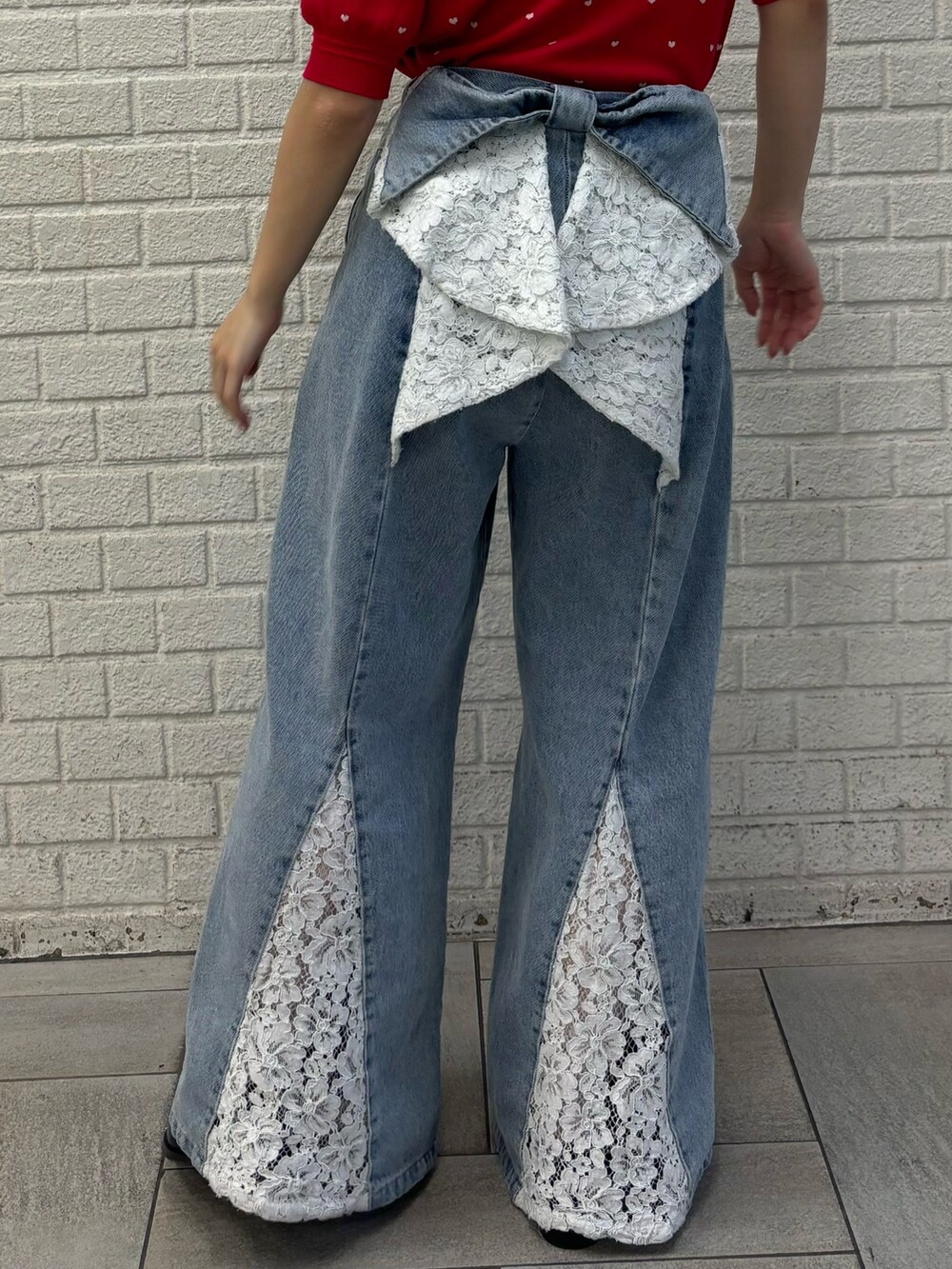 ブルー系のデニムパンツ、レッド系のニット/セーター、ブラック系のバレッタ/ヘアクリップを着用したレディースの夏コーディネートの5枚目の写真