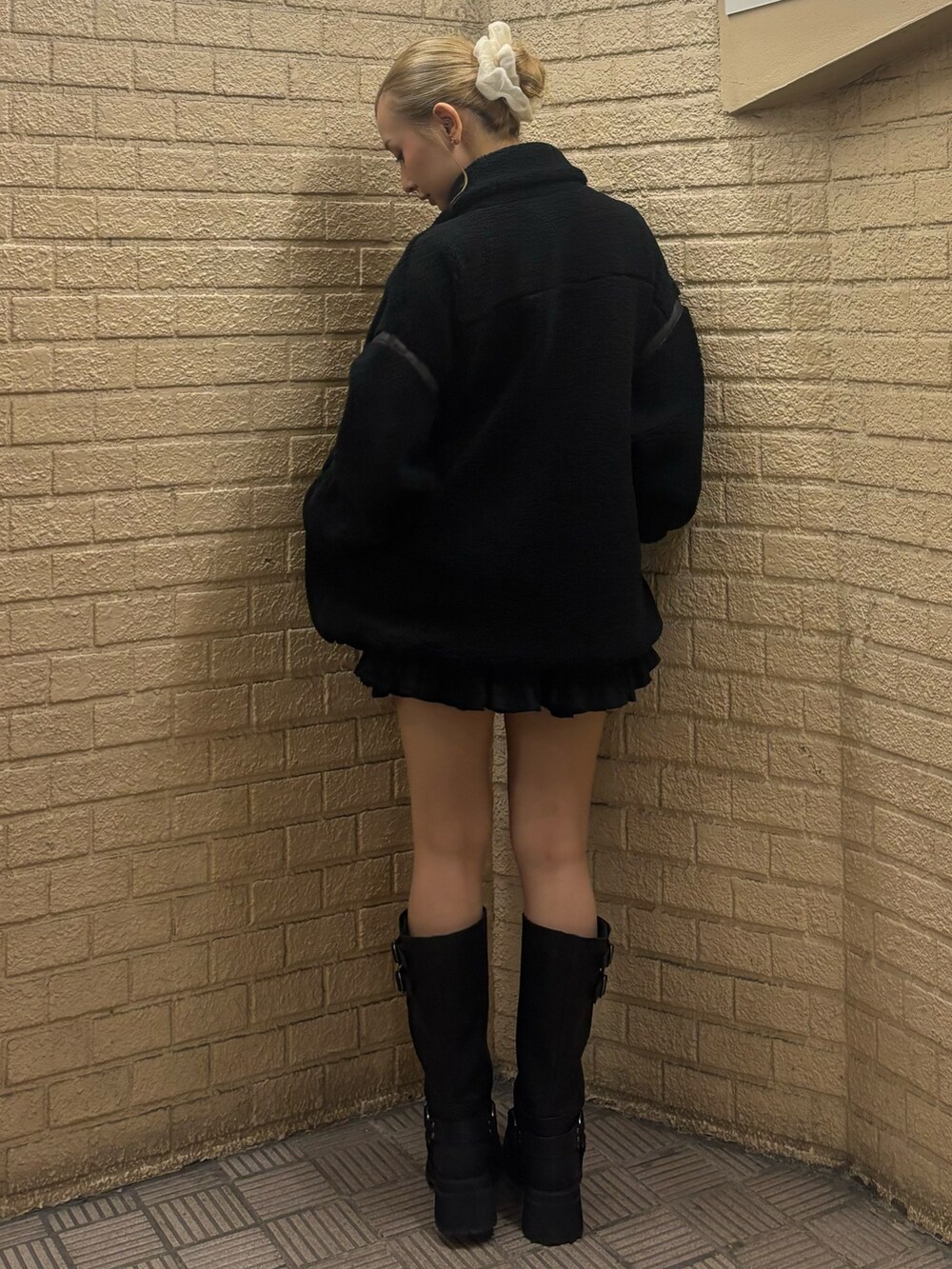 ブラック系のスウェット、ブラック系のスカート、ブラウン系のブーツを着用したレディースの秋コーディネートの3枚目の写真