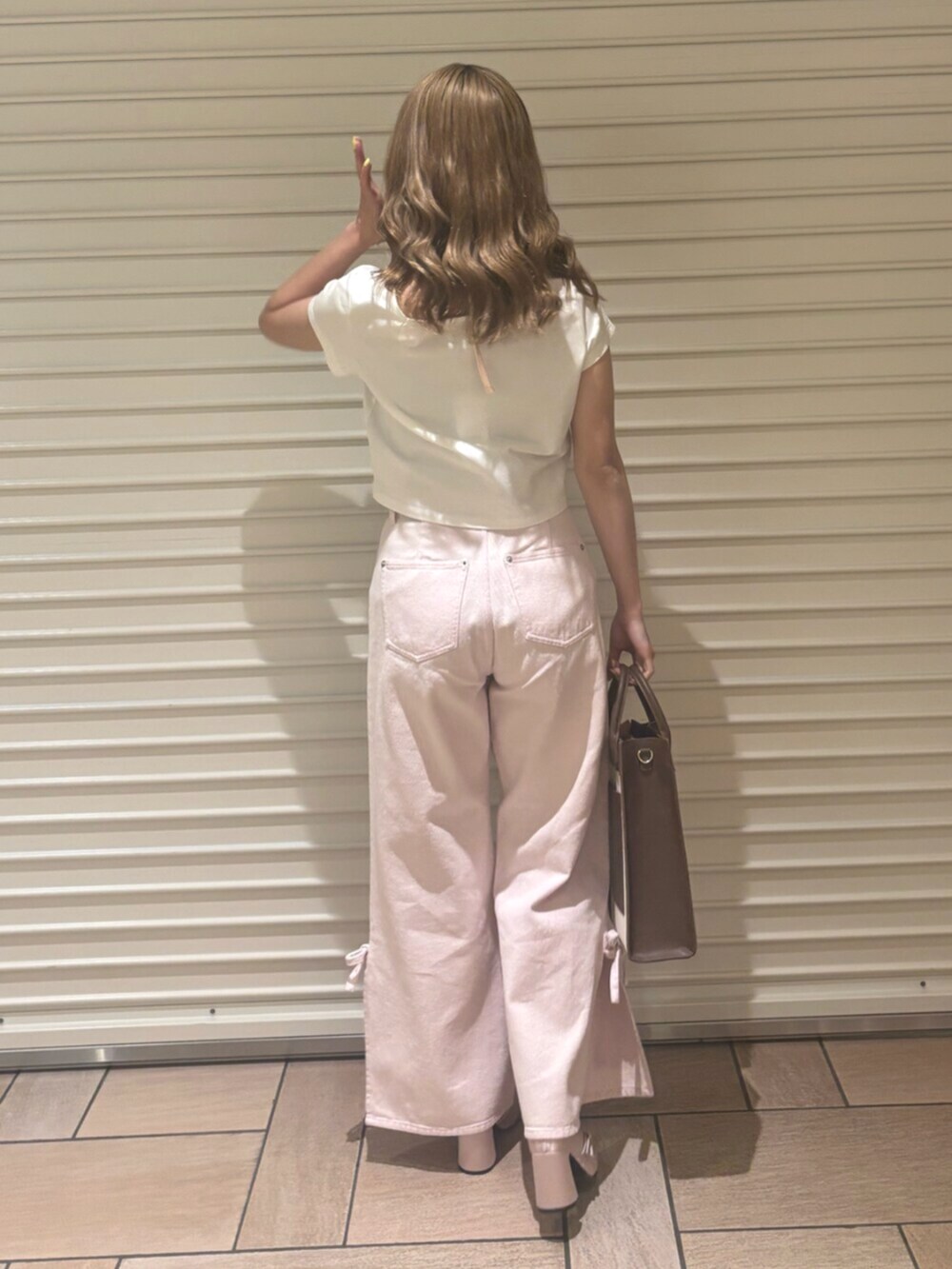 ピンク系のデニムパンツ、ピンク系のTシャツ/カットソー、ピンク系のパンプスを着用したレディースの春コーディネートの4枚目の写真