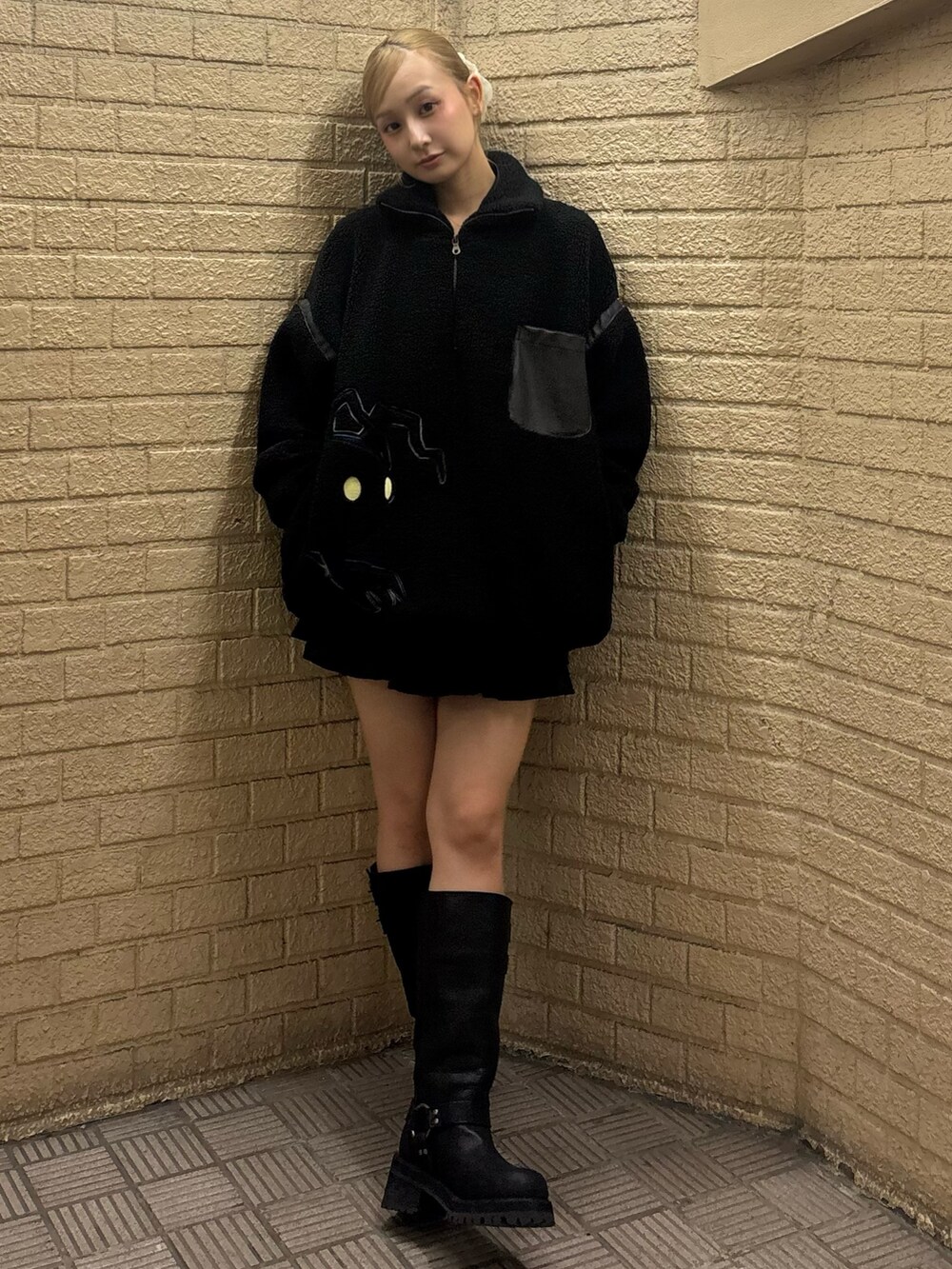 ブラック系のスウェット、ブラック系のスカート、ブラウン系のブーツを着用したレディースの秋コーディネートの5枚目の写真