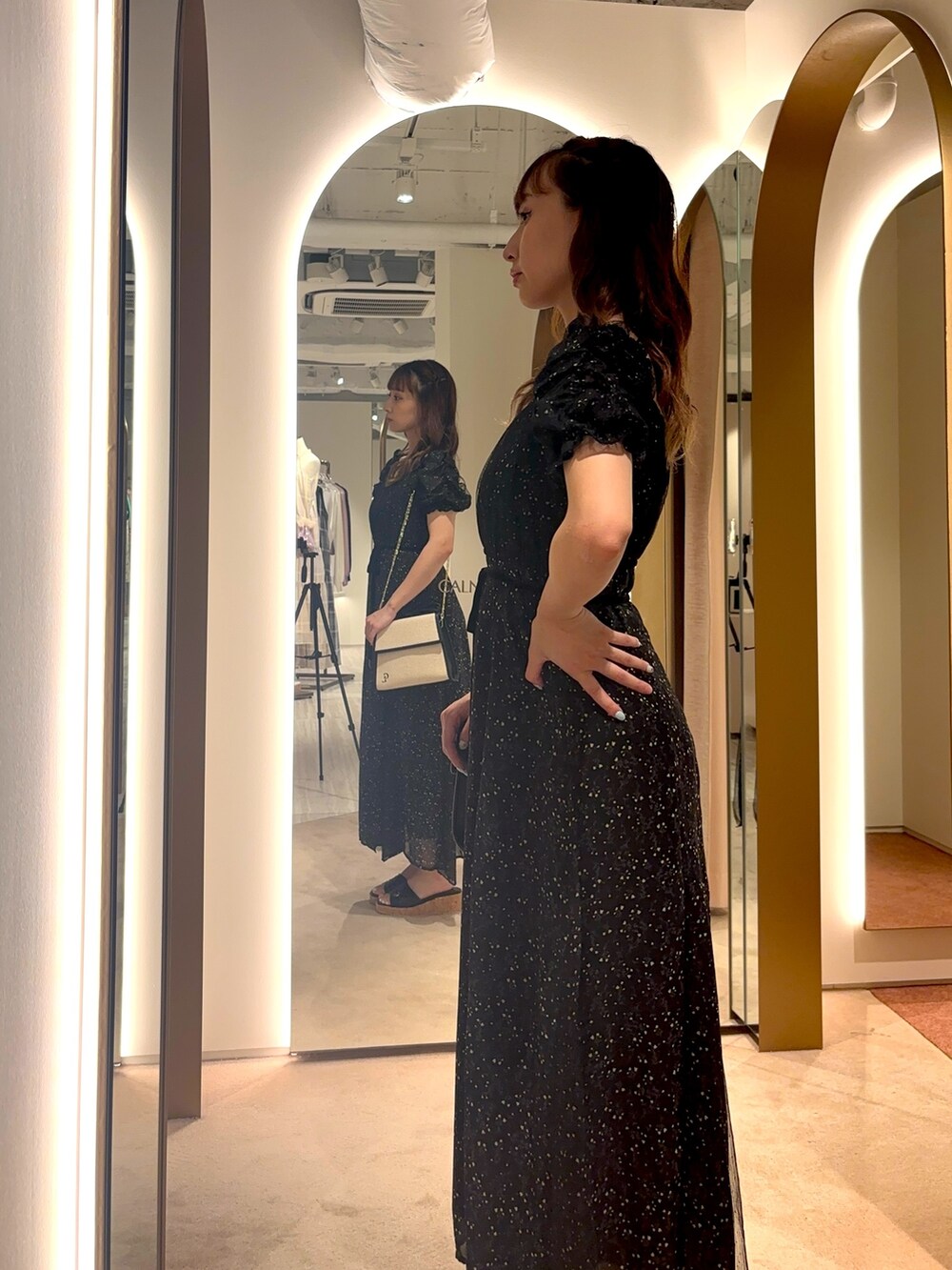 ホワイト系のハンドバッグ、ホワイト系のワンピースを着用したレディースの夏コーディネートの4枚目の写真