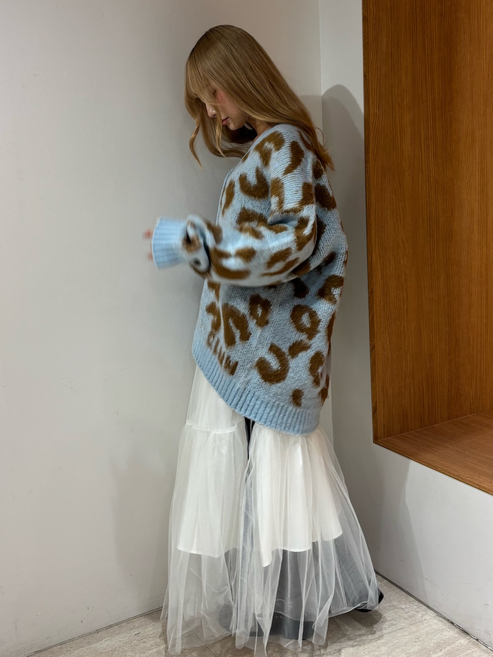 ブルー系のニット/セーター、ホワイト系のスカート、ブラウン系のブーツを着用したレディースの秋コーディネートの4枚目の写真