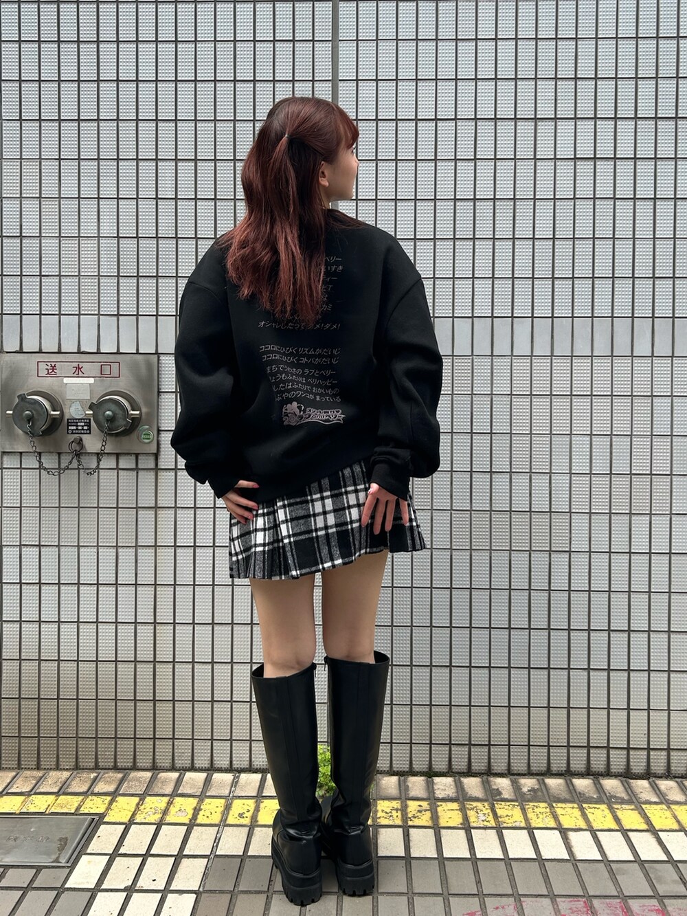 ブラック系のスウェット、レッド系のスカートを着用したレディースの秋コーディネートの6枚目の写真