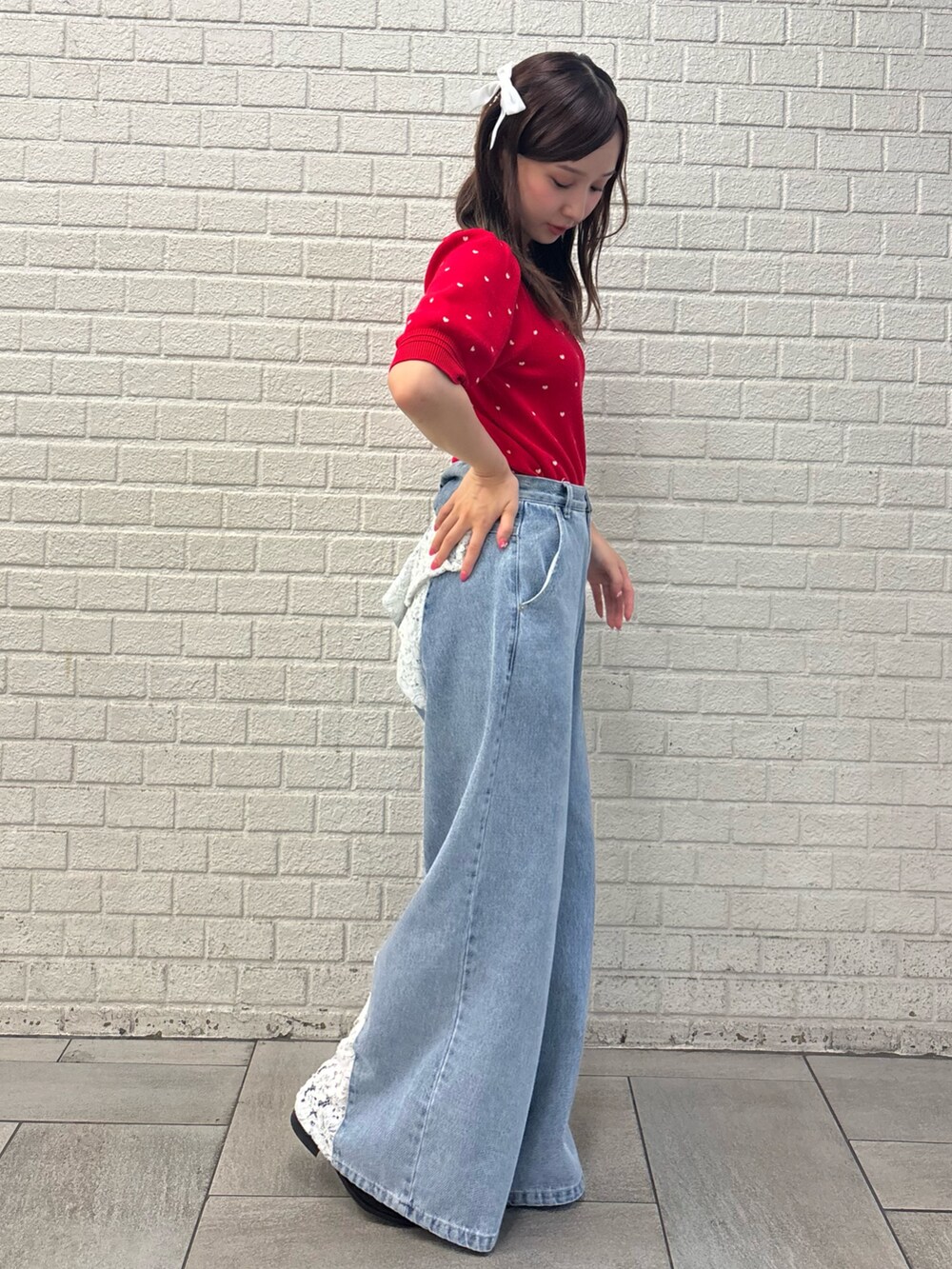 ブルー系のデニムパンツ、レッド系のニット/セーター、ブラック系のバレッタ/ヘアクリップを着用したレディースの夏コーディネートの4枚目の写真
