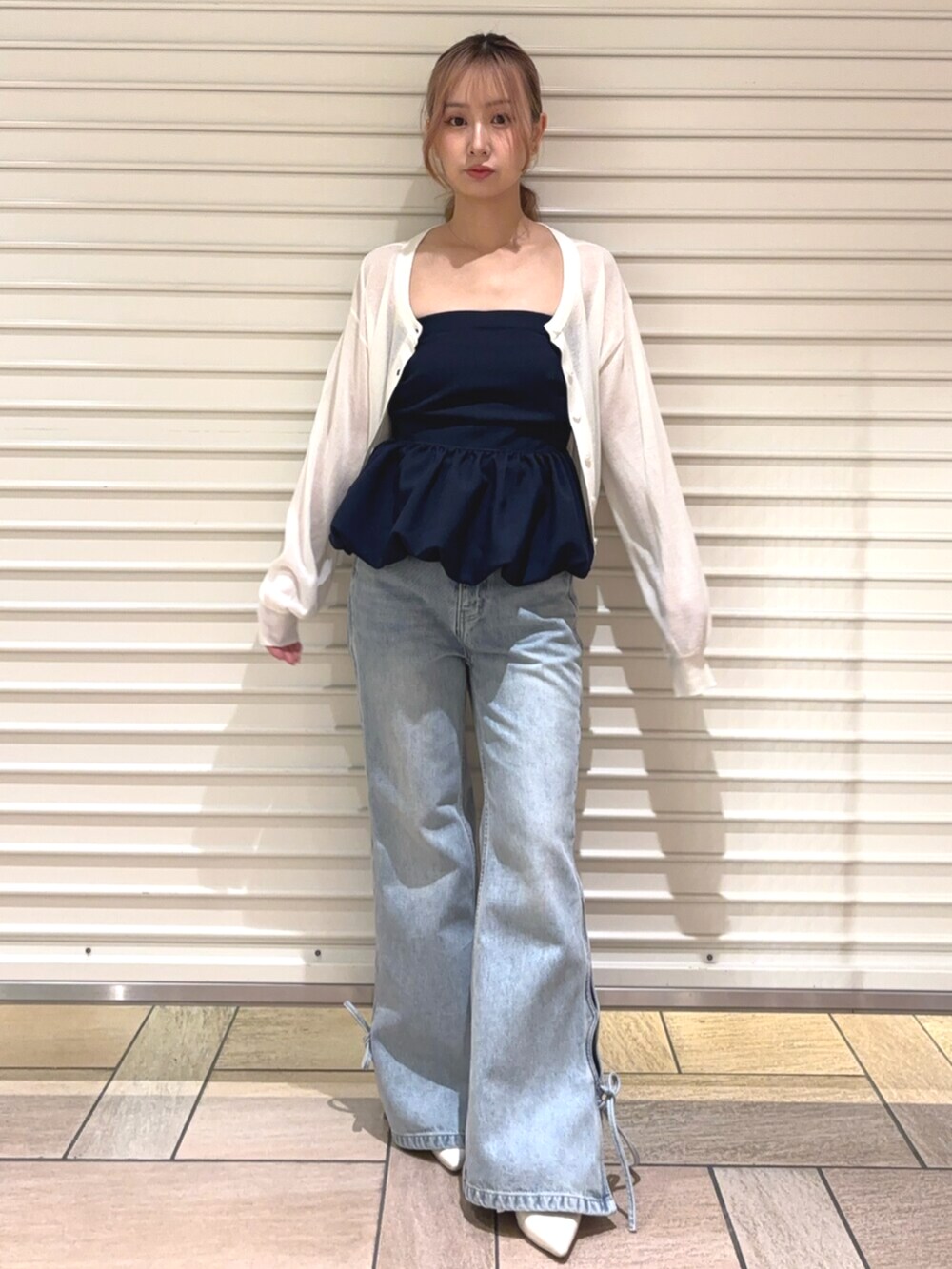 ホワイト系のカーディガン/ボレロ、ブルー系のデニムパンツ、ブルー系のチューブトップを着用したレディースの春コーディネートの3枚目の写真