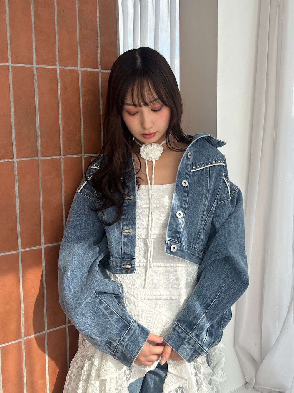 ホワイト系のワンピース、ブルー系のデニムジャケット、ブルー系のその他パンツを着用したレディースの冬コーディネートの4枚目の写真