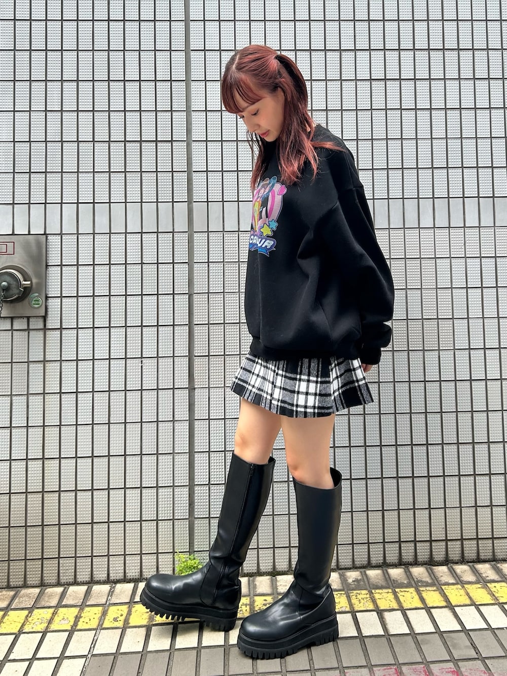 ブラック系のスウェット、レッド系のスカートを着用したレディースの秋コーディネートの2枚目の写真