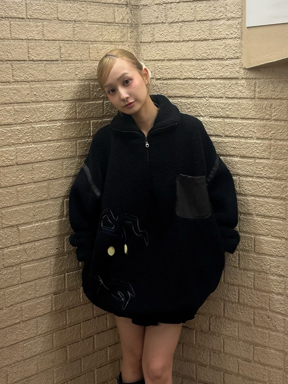 ブラック系のスウェット、ブラック系のスカート、ブラウン系のブーツを着用したレディースの秋コーディネートの4枚目の写真