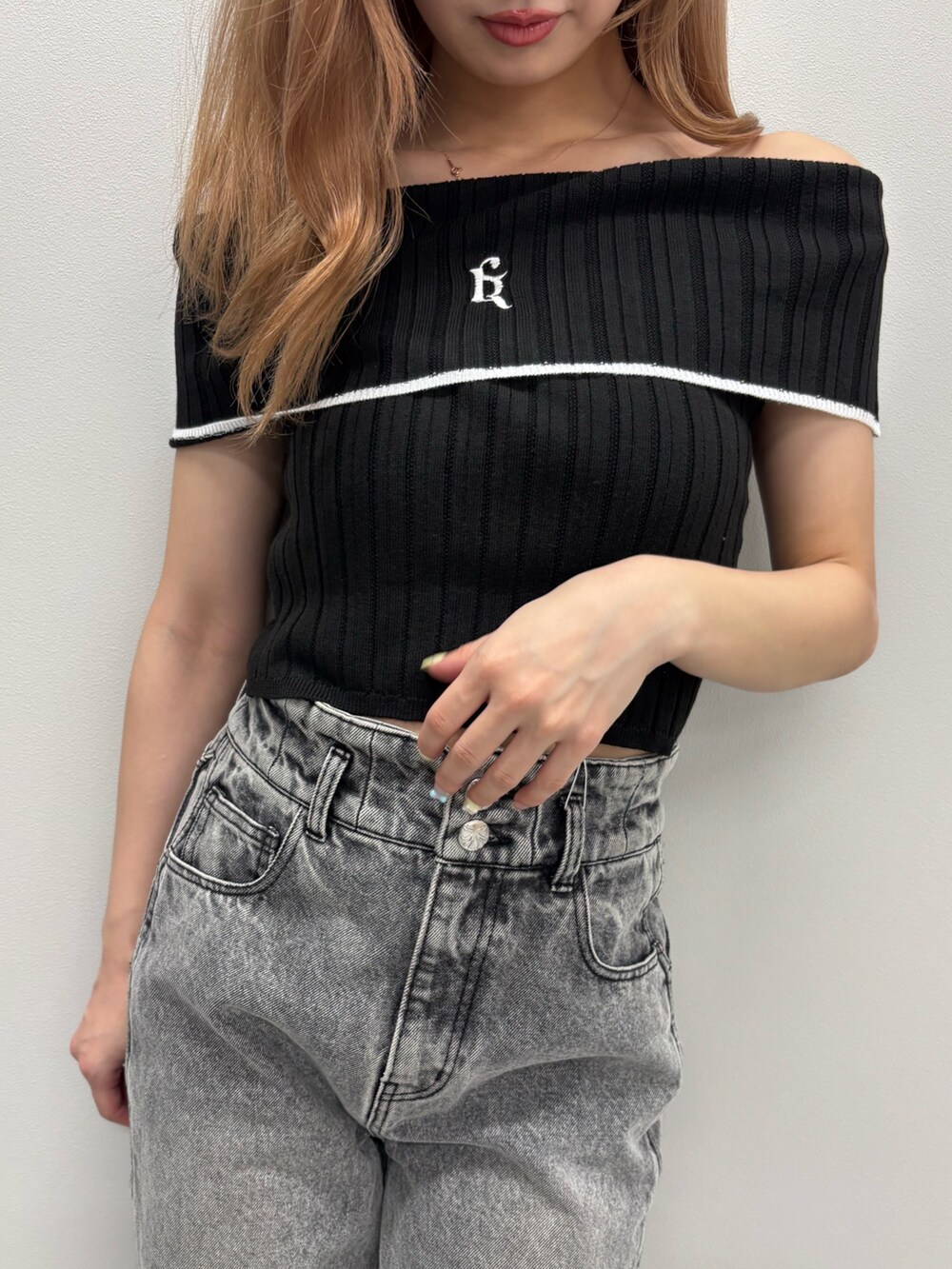 ブルー系のデニムパンツ、ブラック系のニット/セーター、ホワイト系のサンダルを着用したレディースの春コーディネートの7枚目の写真