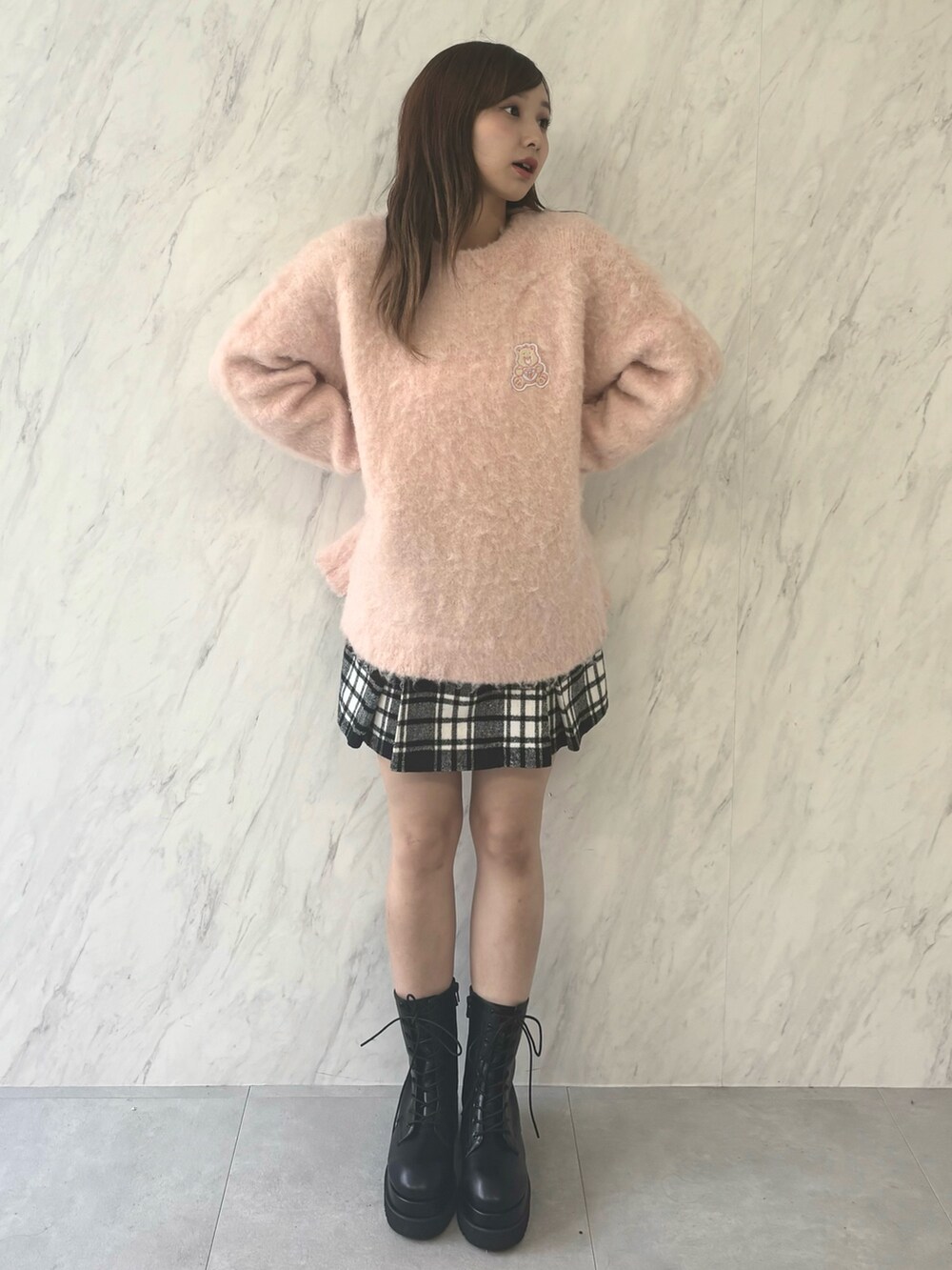 ホワイト系のニット/セーター、レッド系のスカート、ブラック系のブーツを着用したレディースの夏コーディネートの2枚目の写真